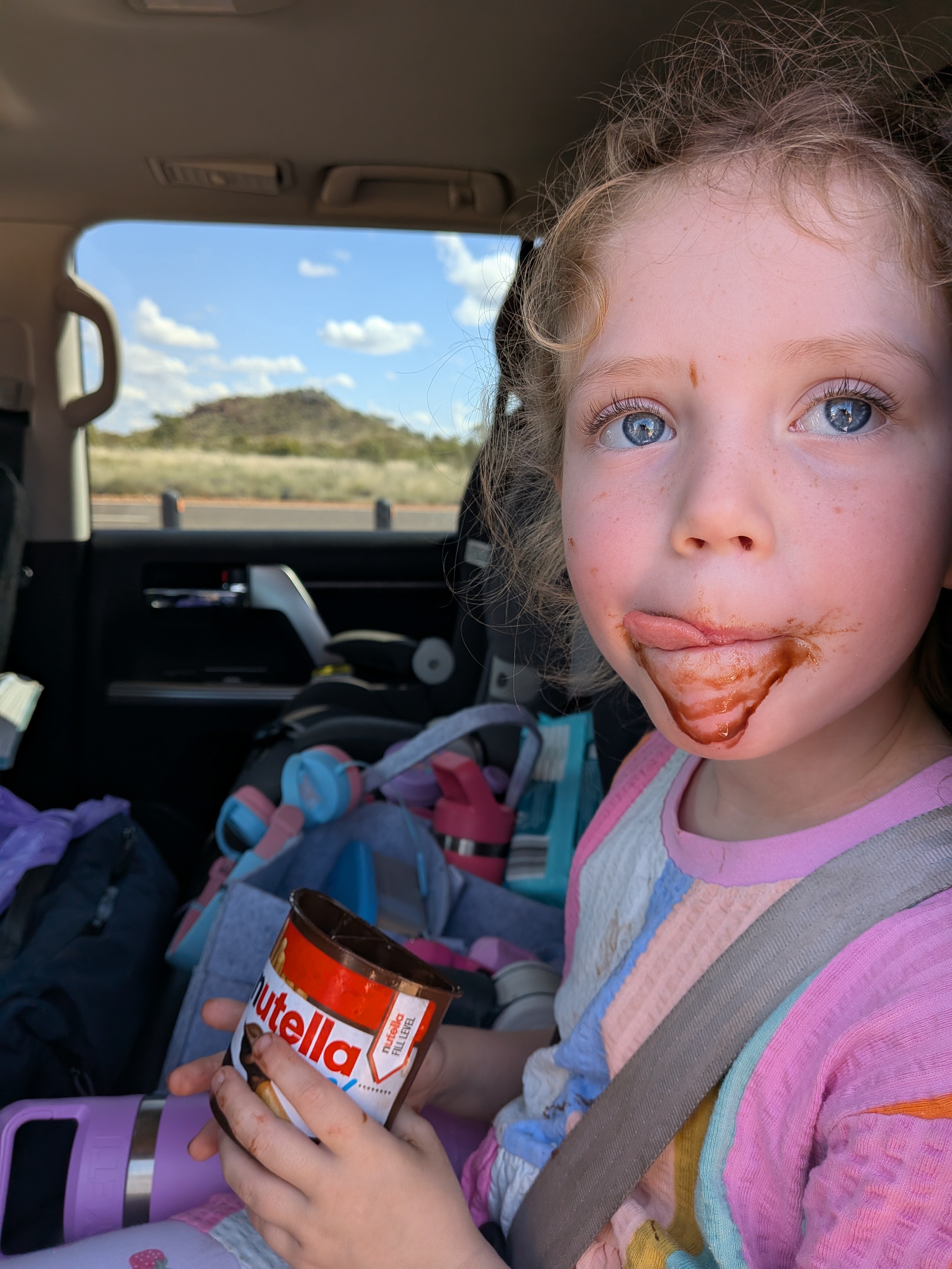 Leah covered in Nutella in the back seat