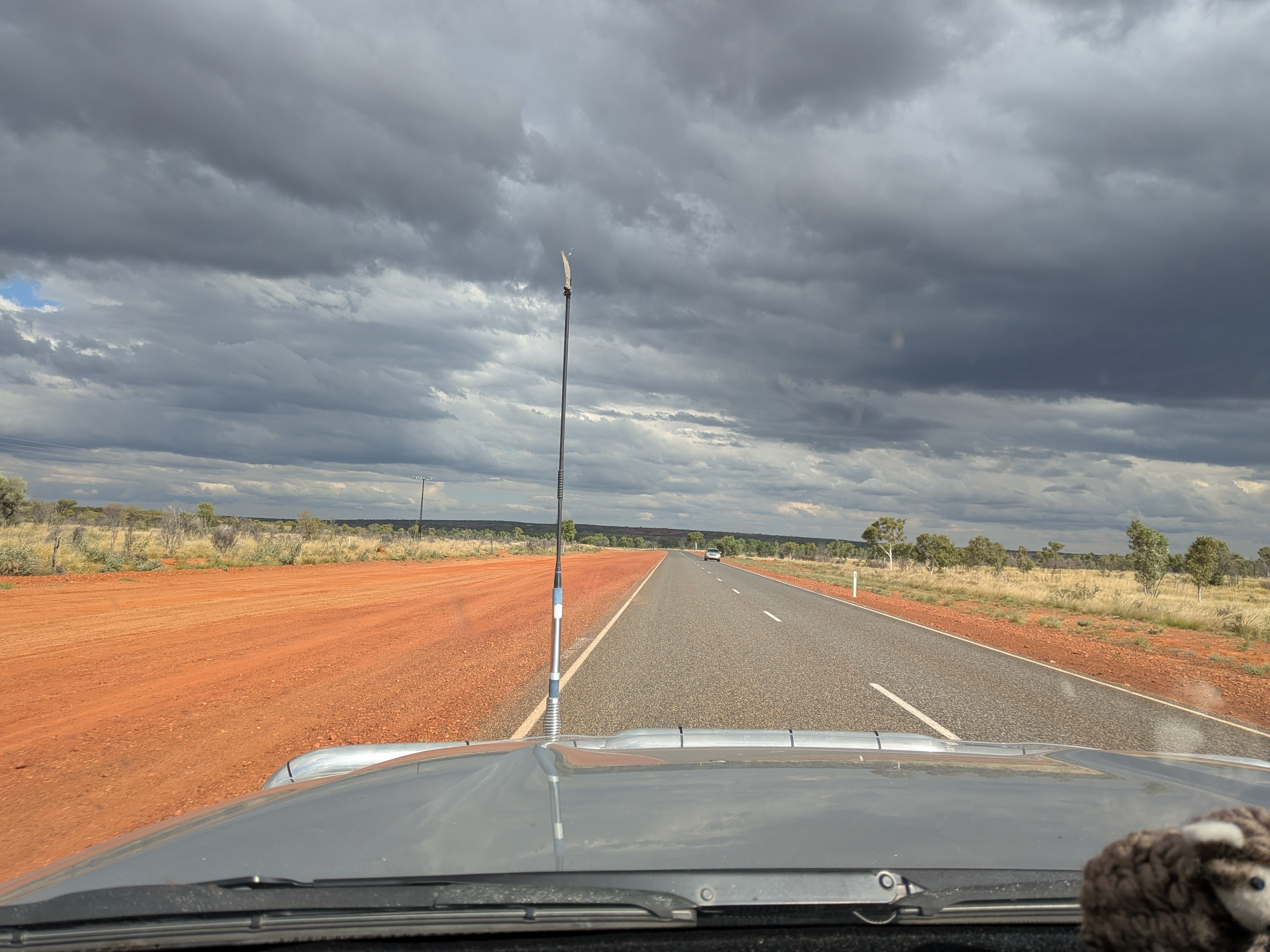 Red dirt highway under stormy skies south of Tennant Creek