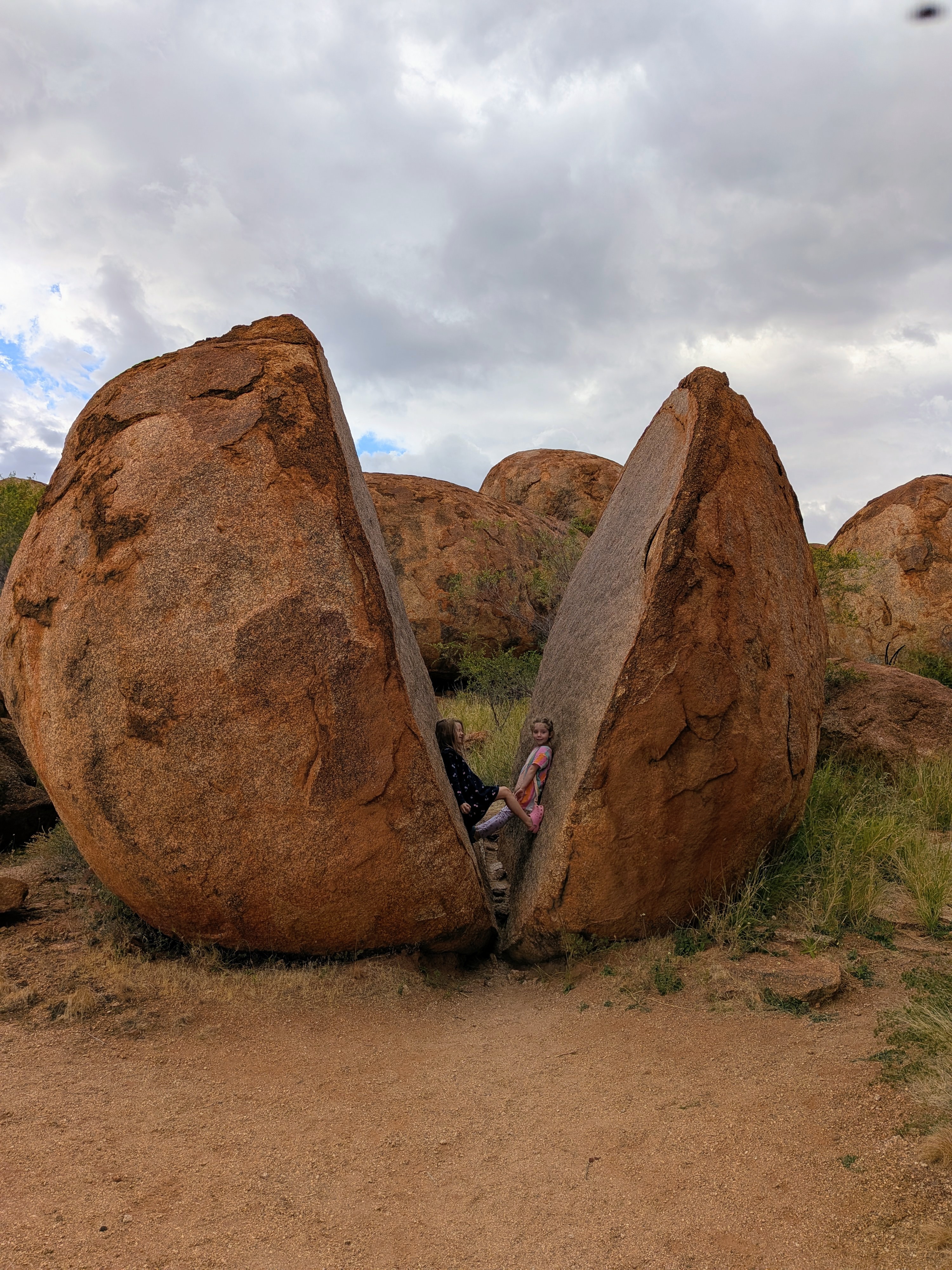 Leah sitting inside a split boulder at the Devil's Marbles