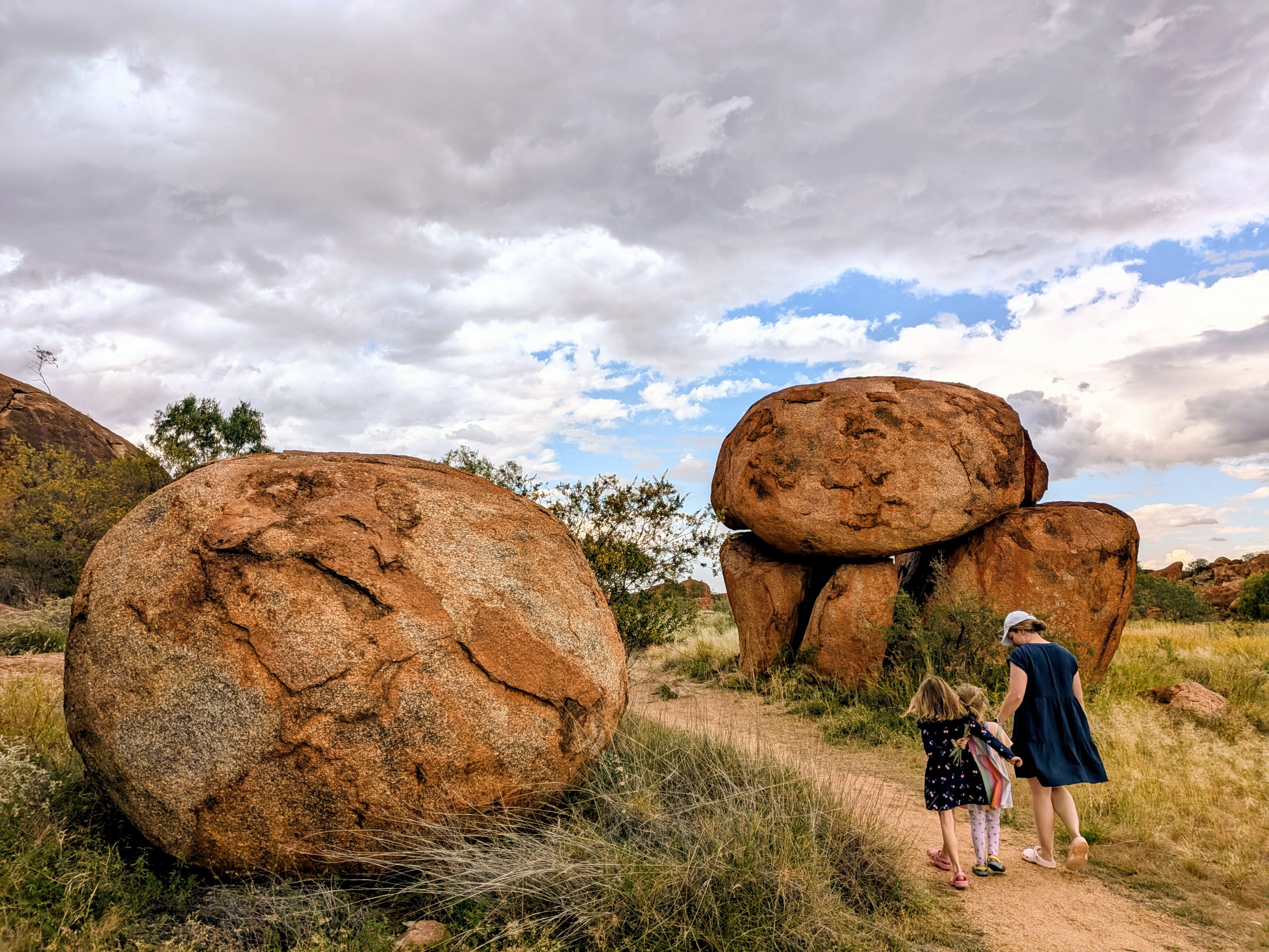 Erin and the girls walking past the giant boulders at the Devil's Marbles