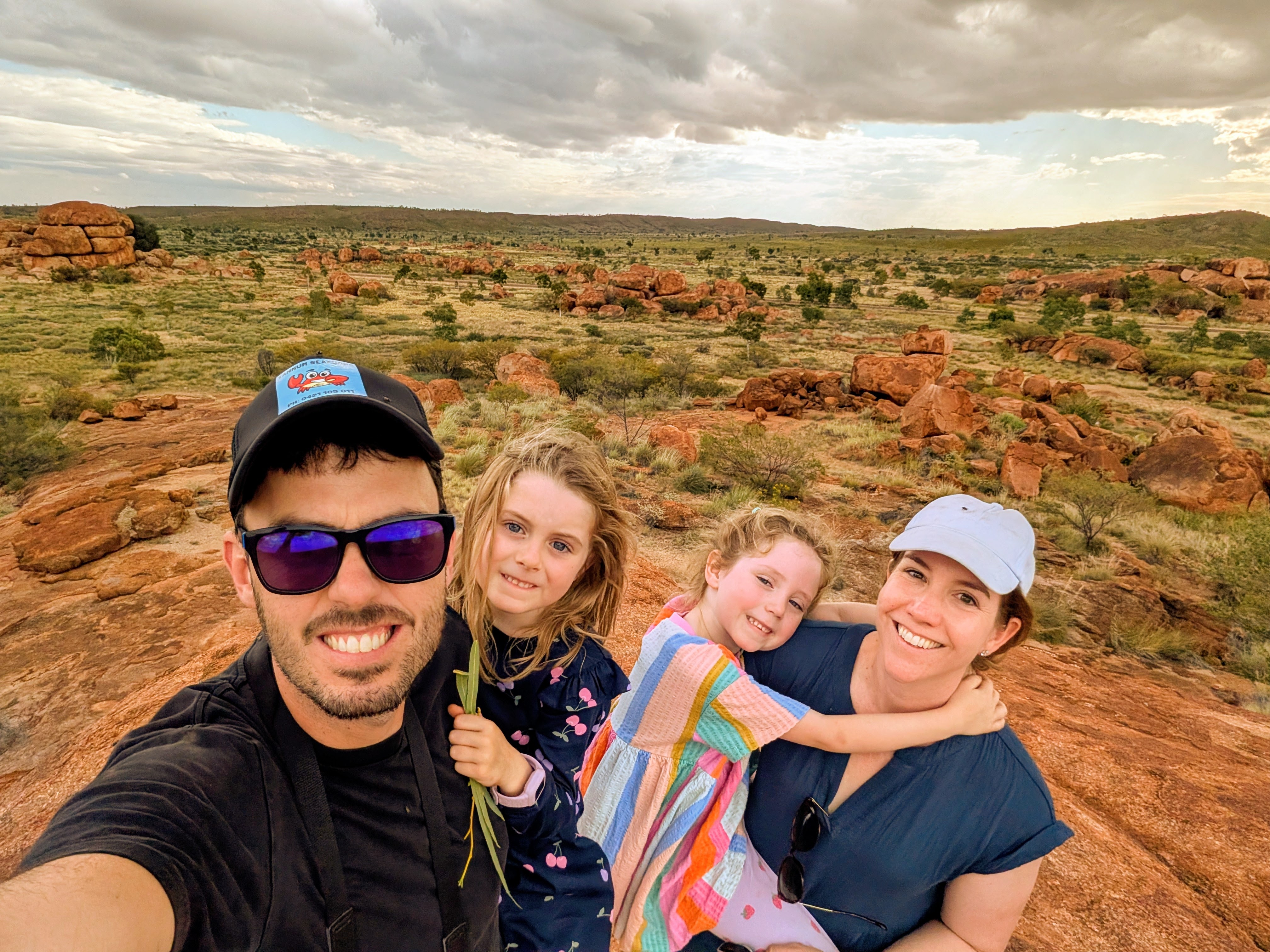 Family selfie on top of the Devil's Marbles with the landscape stretching out behind