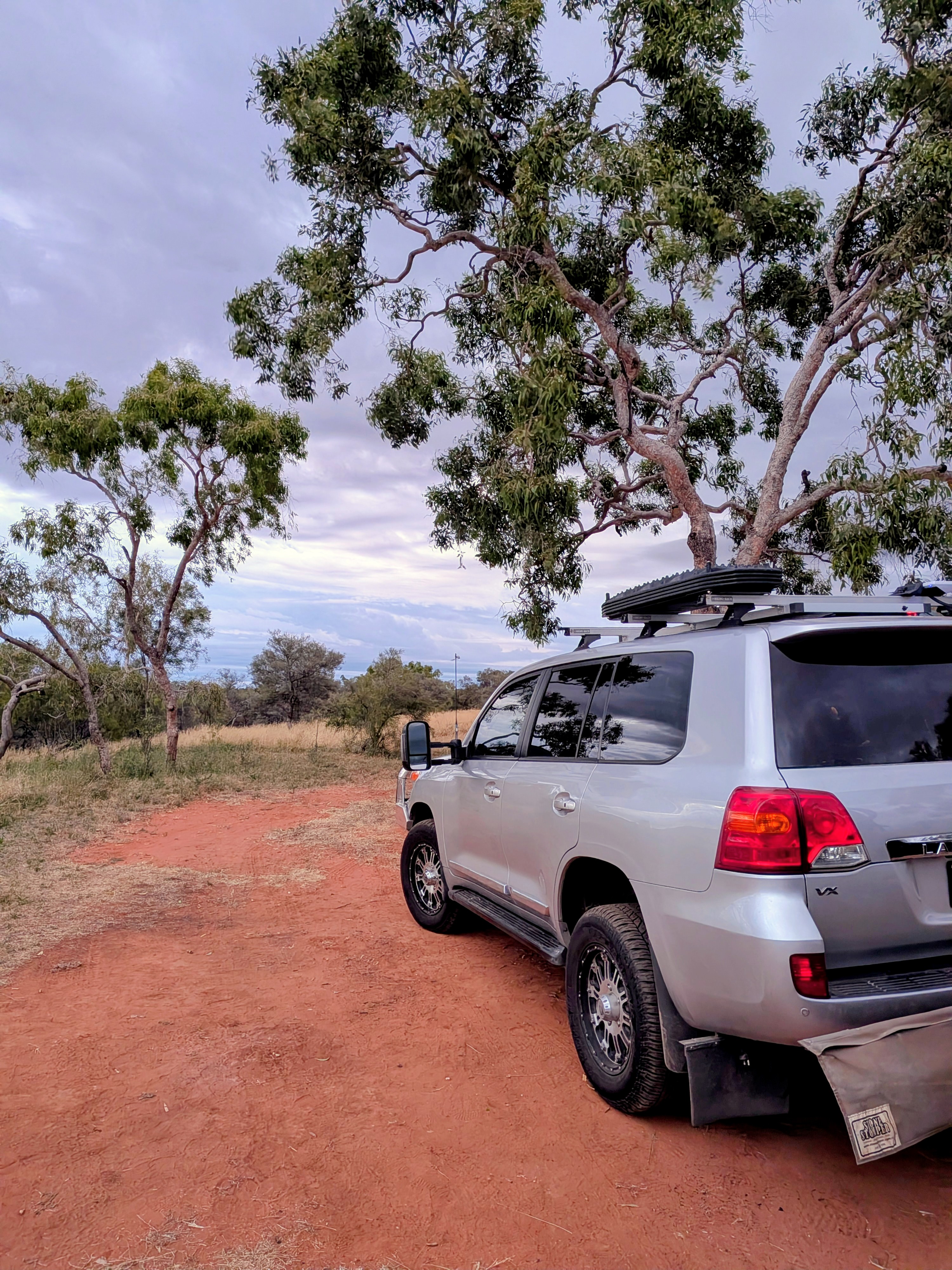 Reg parked on the red dirt under the gum trees