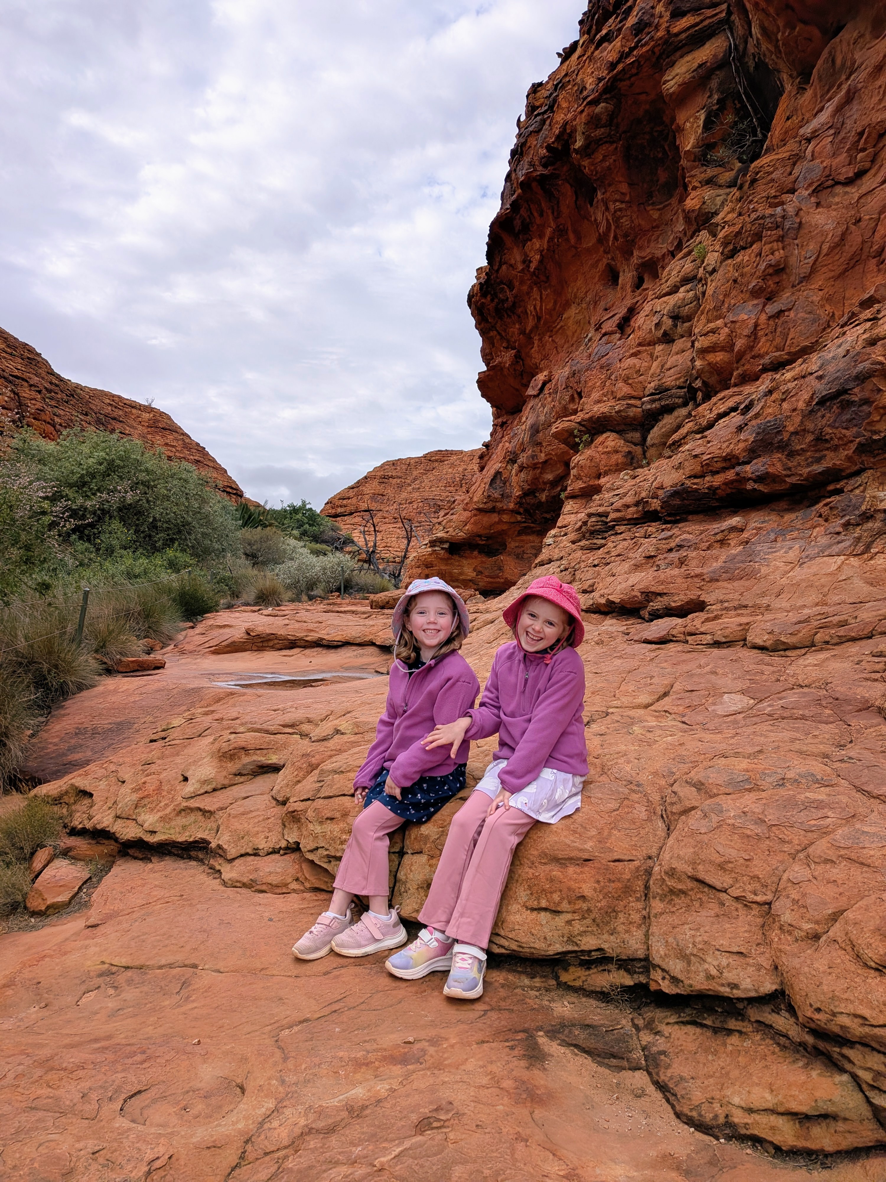 The girls sitting on the red rock at Kings Canyon