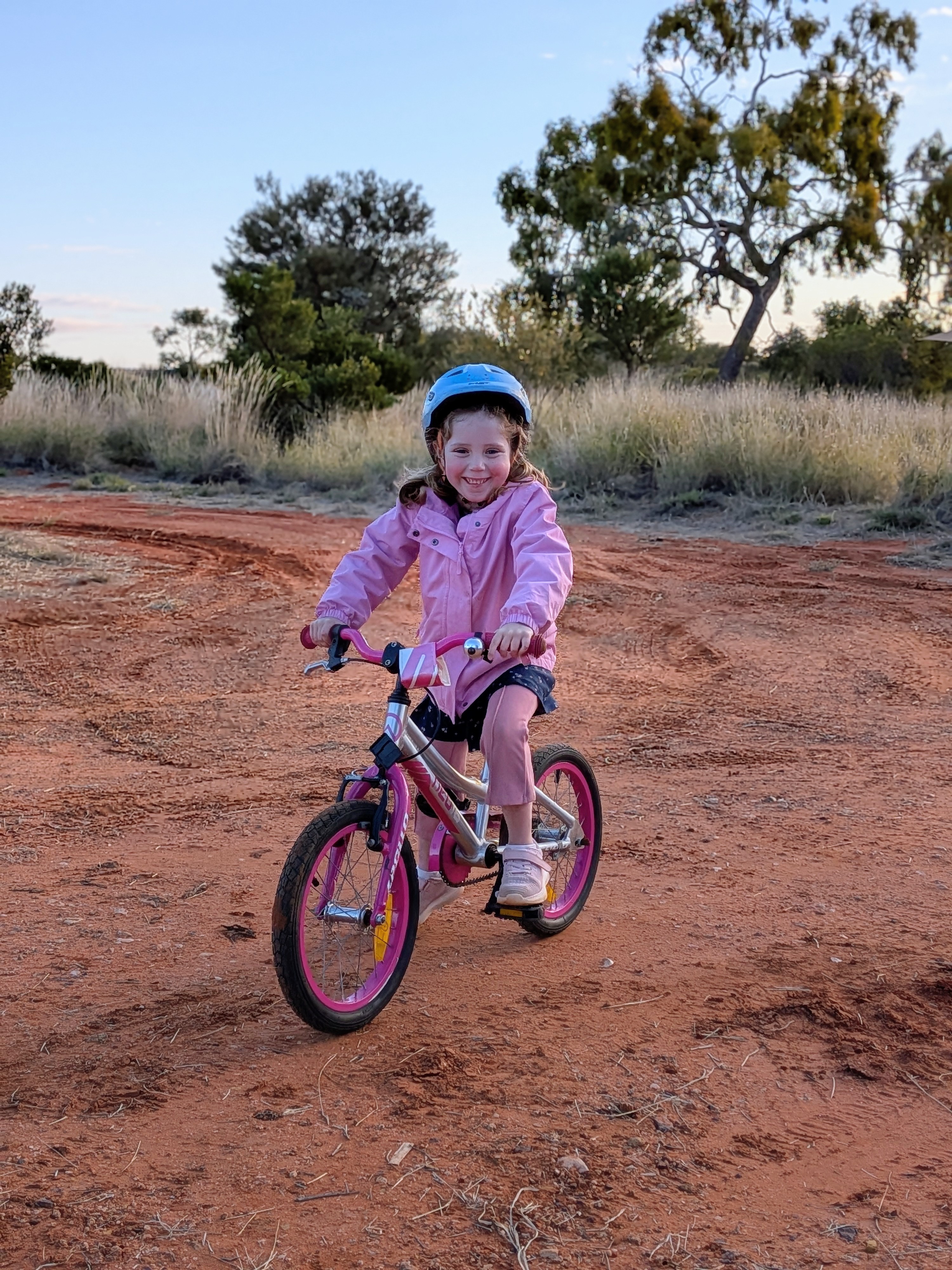 Leah bike riding on the red dirt at Kings Creek Station