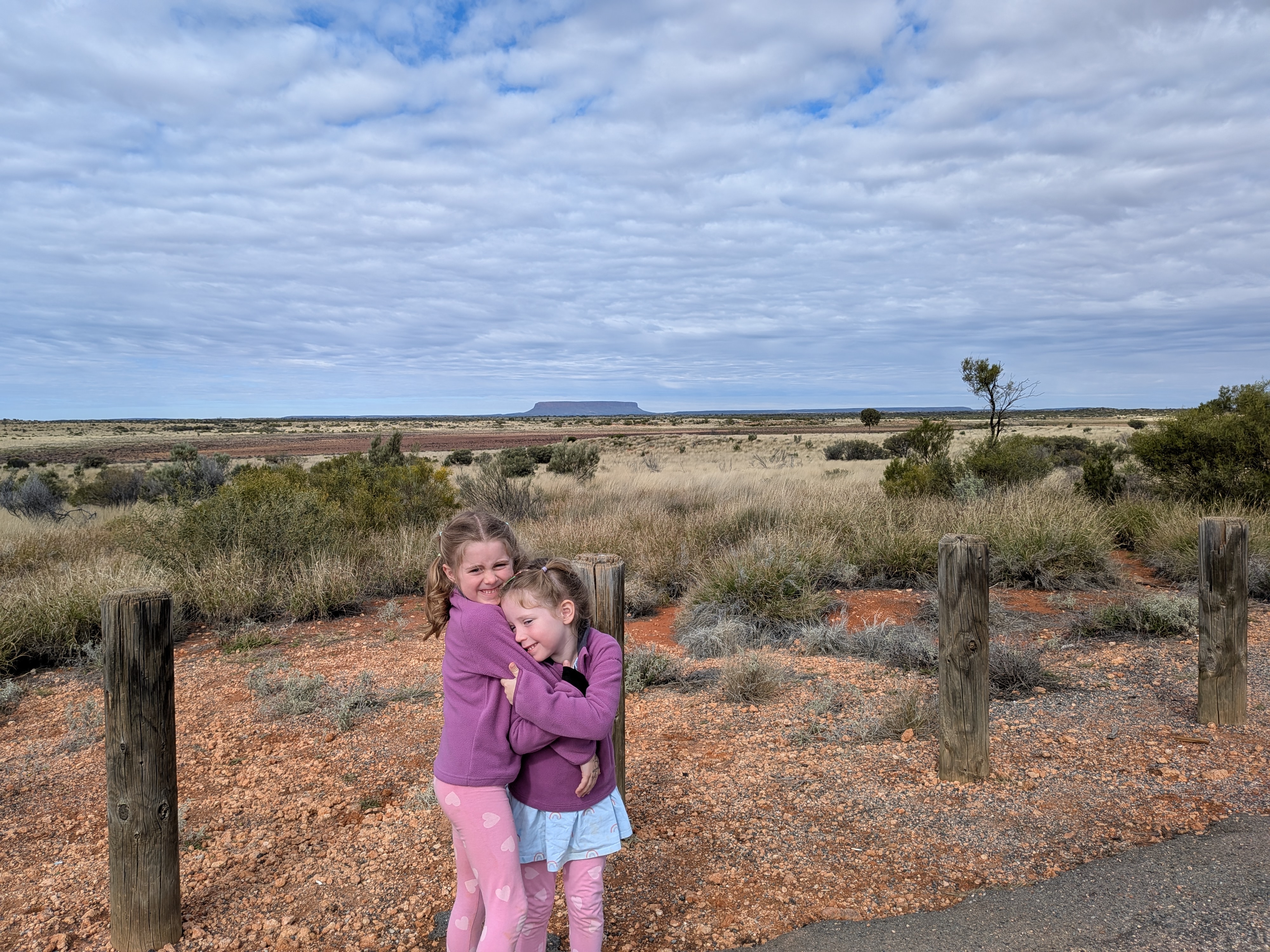 The girls hugging with Mount Connor (Fooluru) in the background