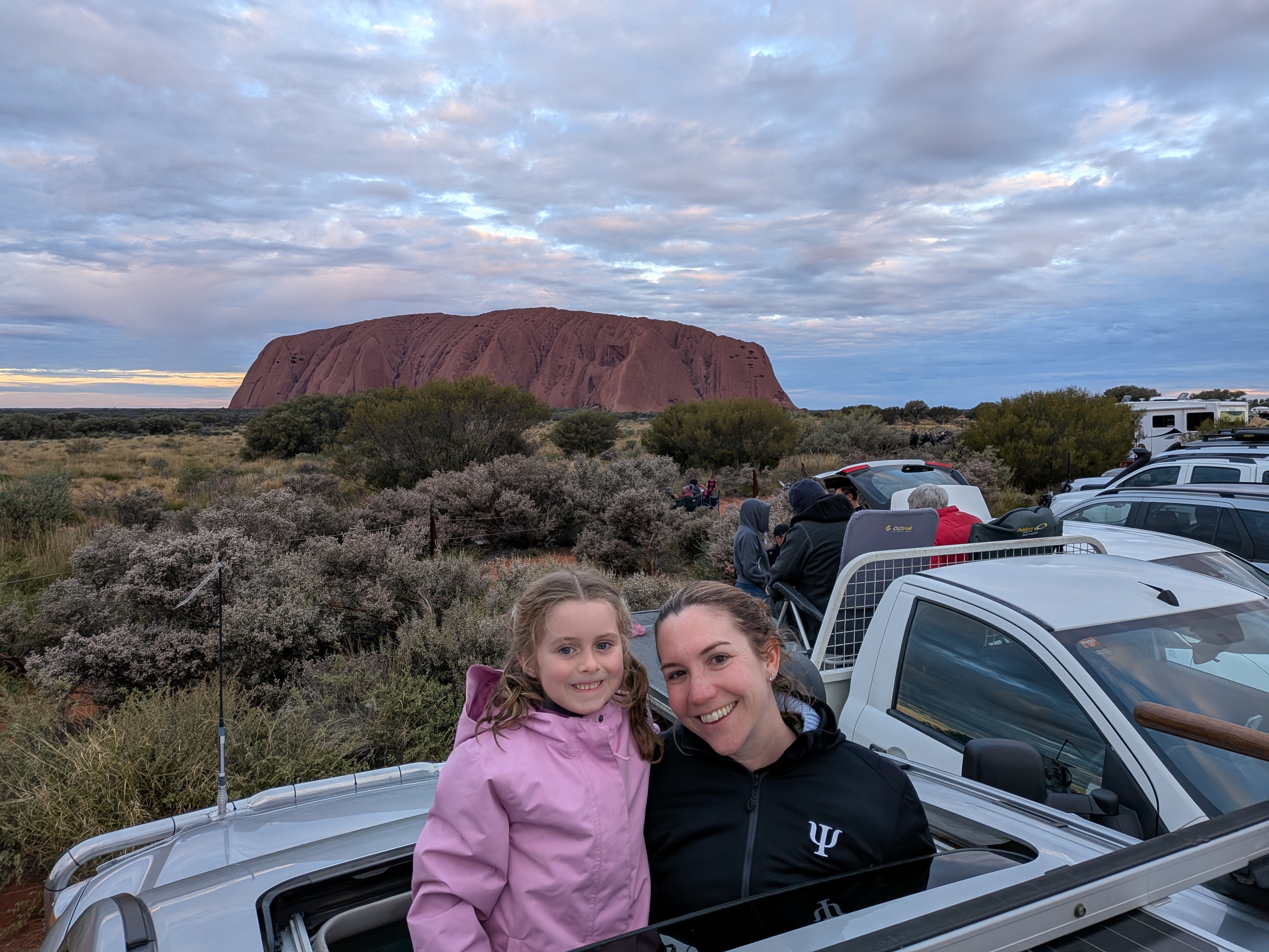 Erin and Hazel with Uluru glowing behind at sunset