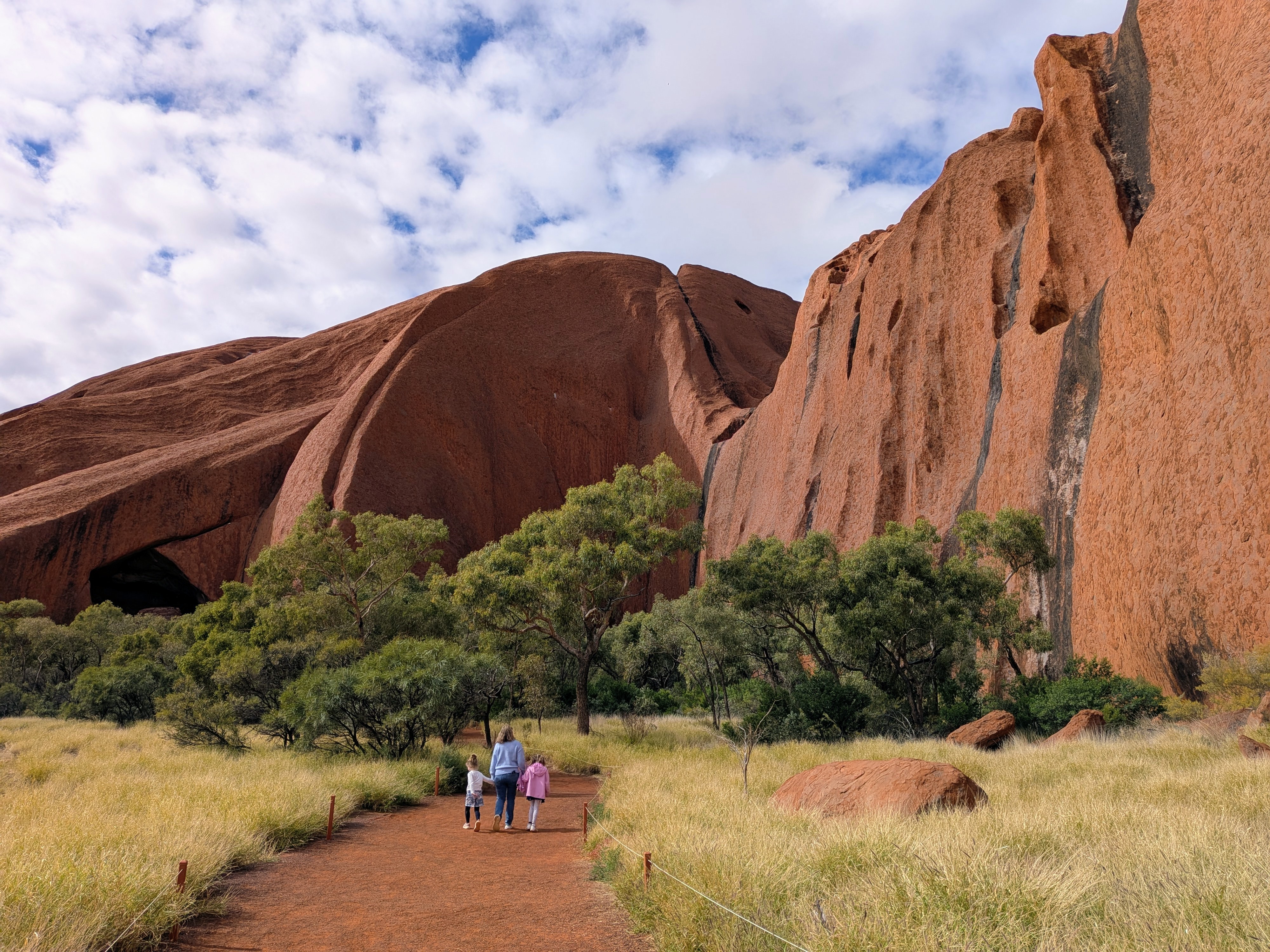 Erin and the girls walking toward the cliff face at Uluru