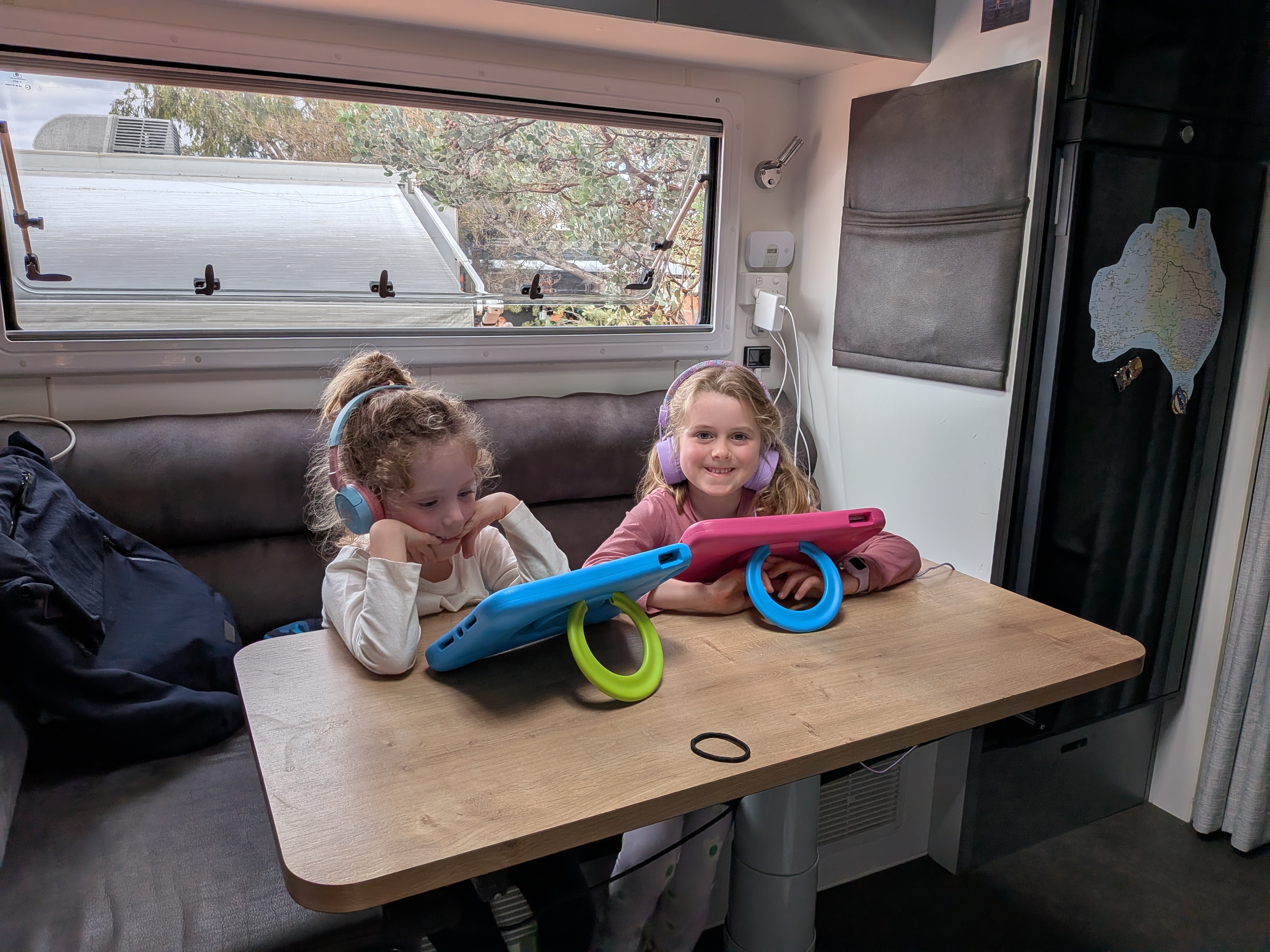 The girls on iPads with headphones in the van — screen time delivered