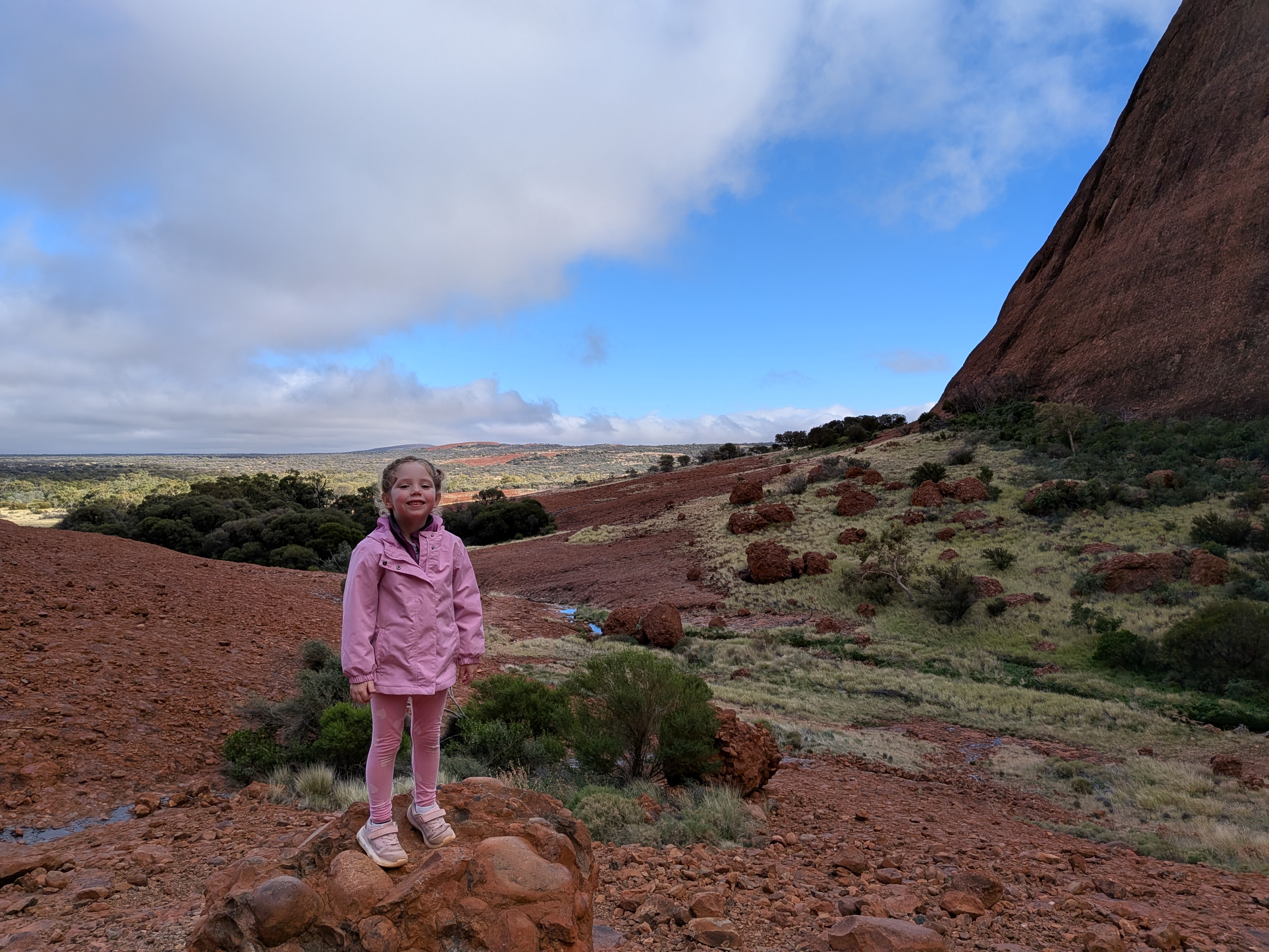 Leah standing on a rock at Kata Tjuta with the landscape behind