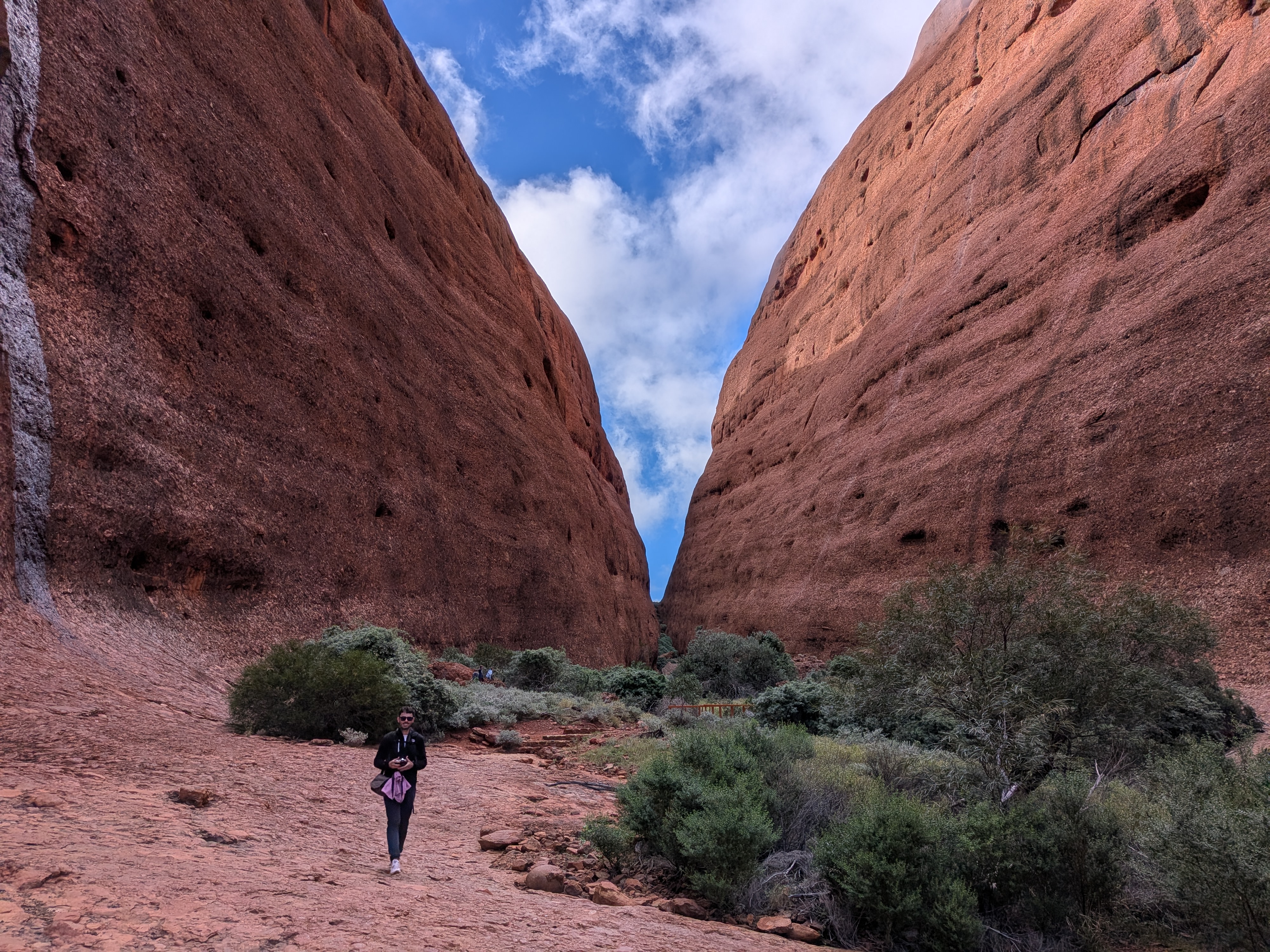 Erin walking through Walpa Gorge between the towering red walls