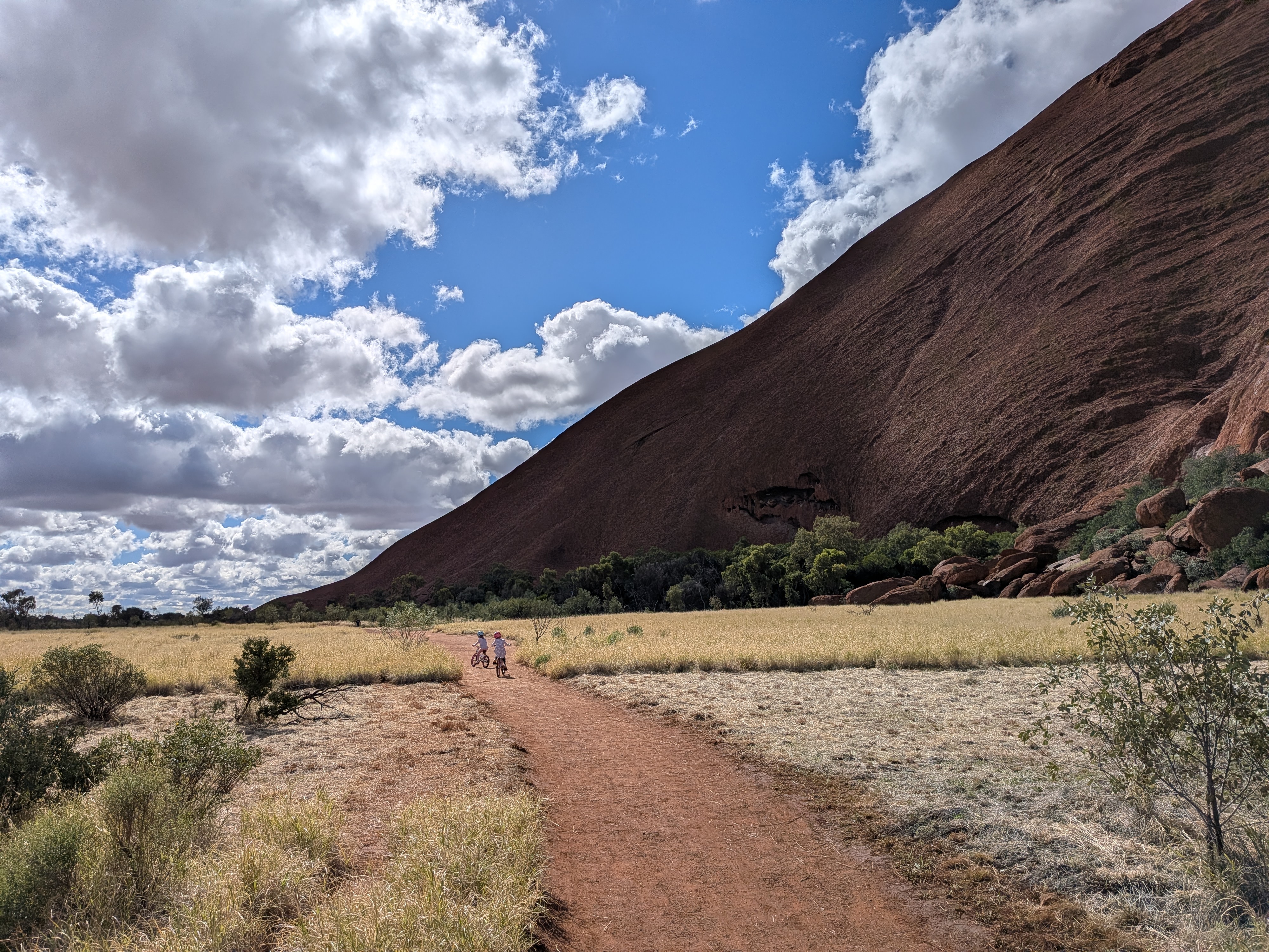 The girls biking along the base of Uluru
