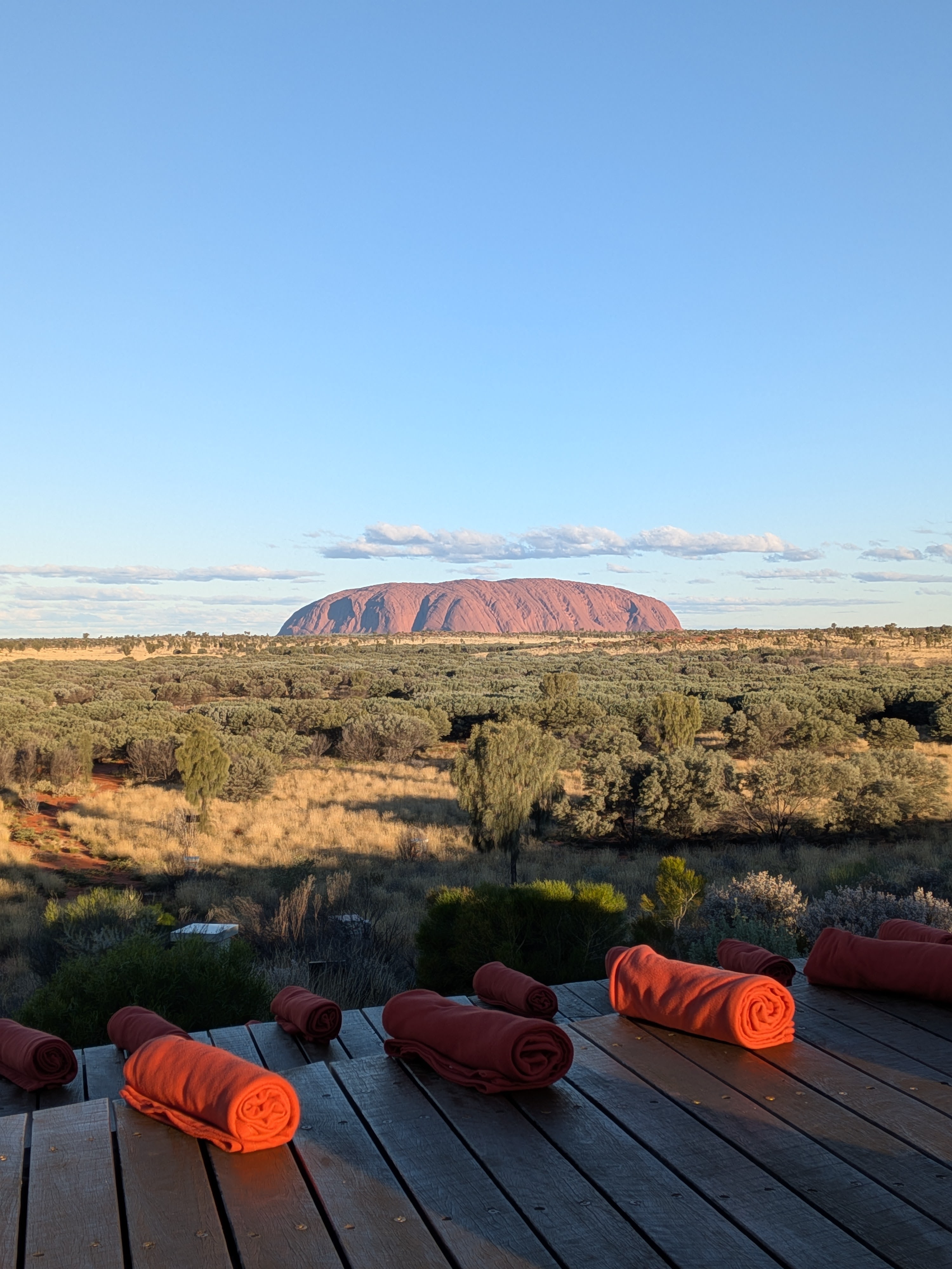 Uluru from the Wintjiri Wiru deck with rolled blankets in the golden light