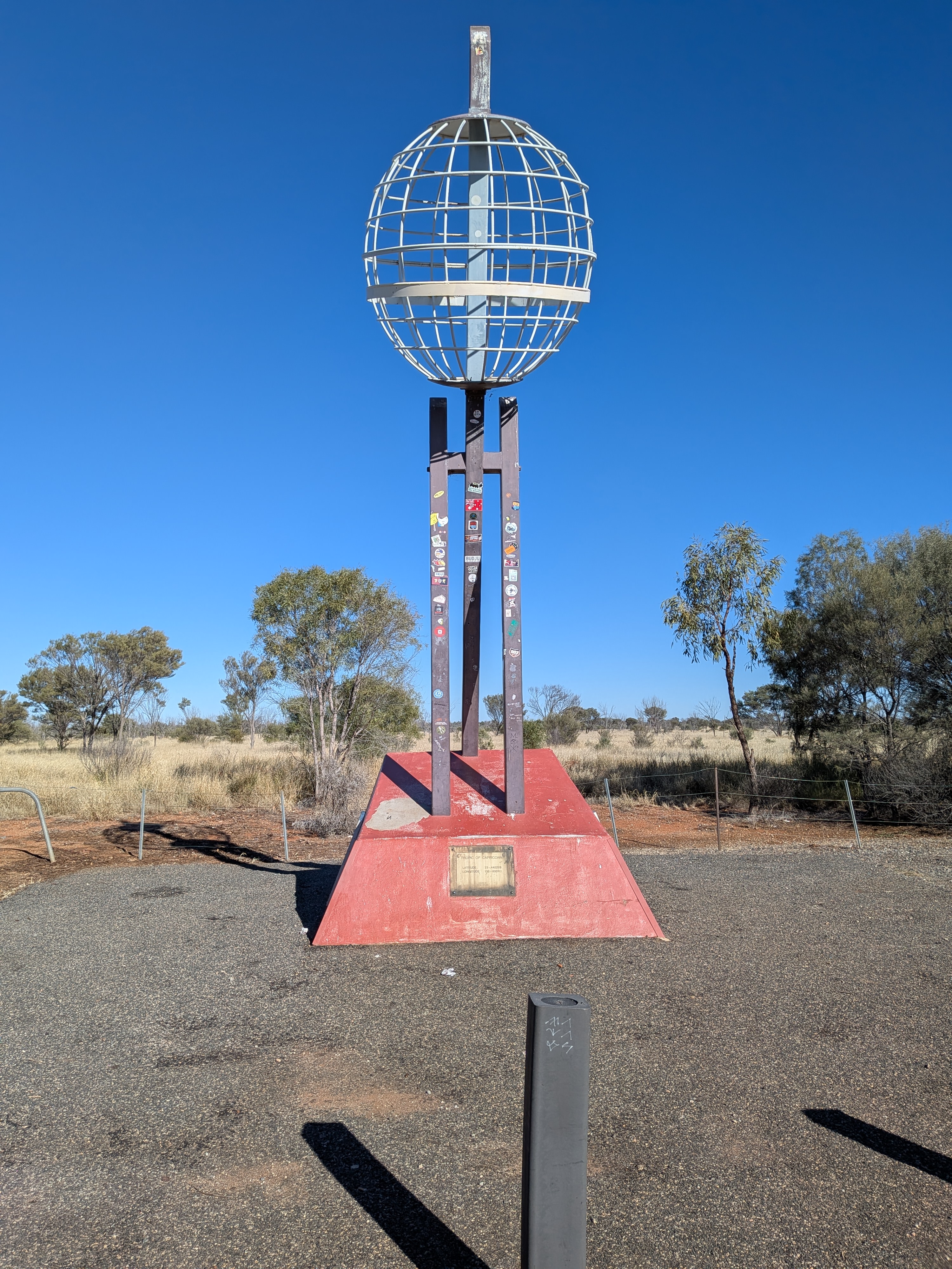 The Tropic of Capricorn monument beside the Stuart Highway, a wire globe on a sticker-covered pedestal