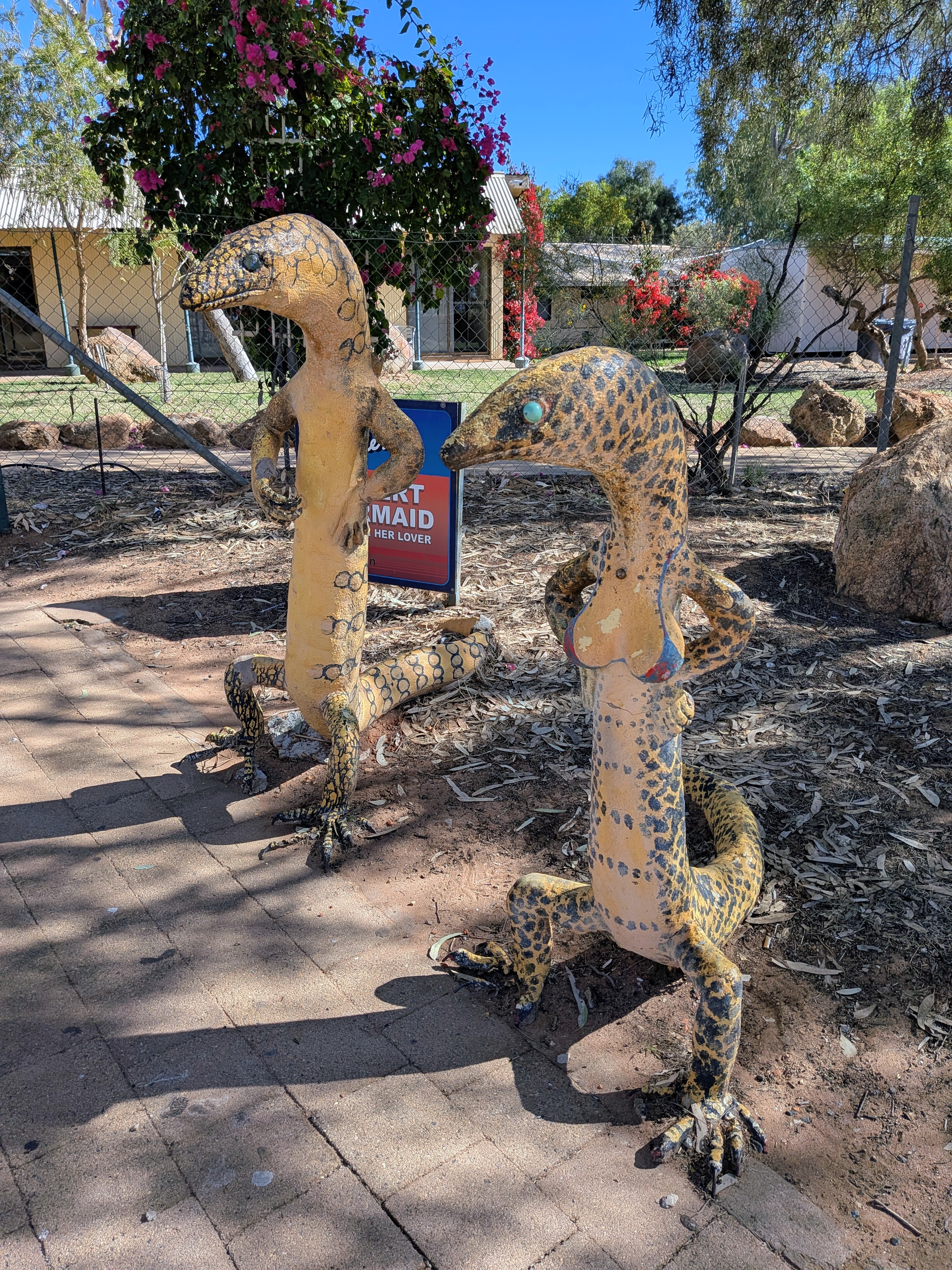 The Desert Mermaid and her lover, two painted lizard sculptures at Aileron Roadhouse