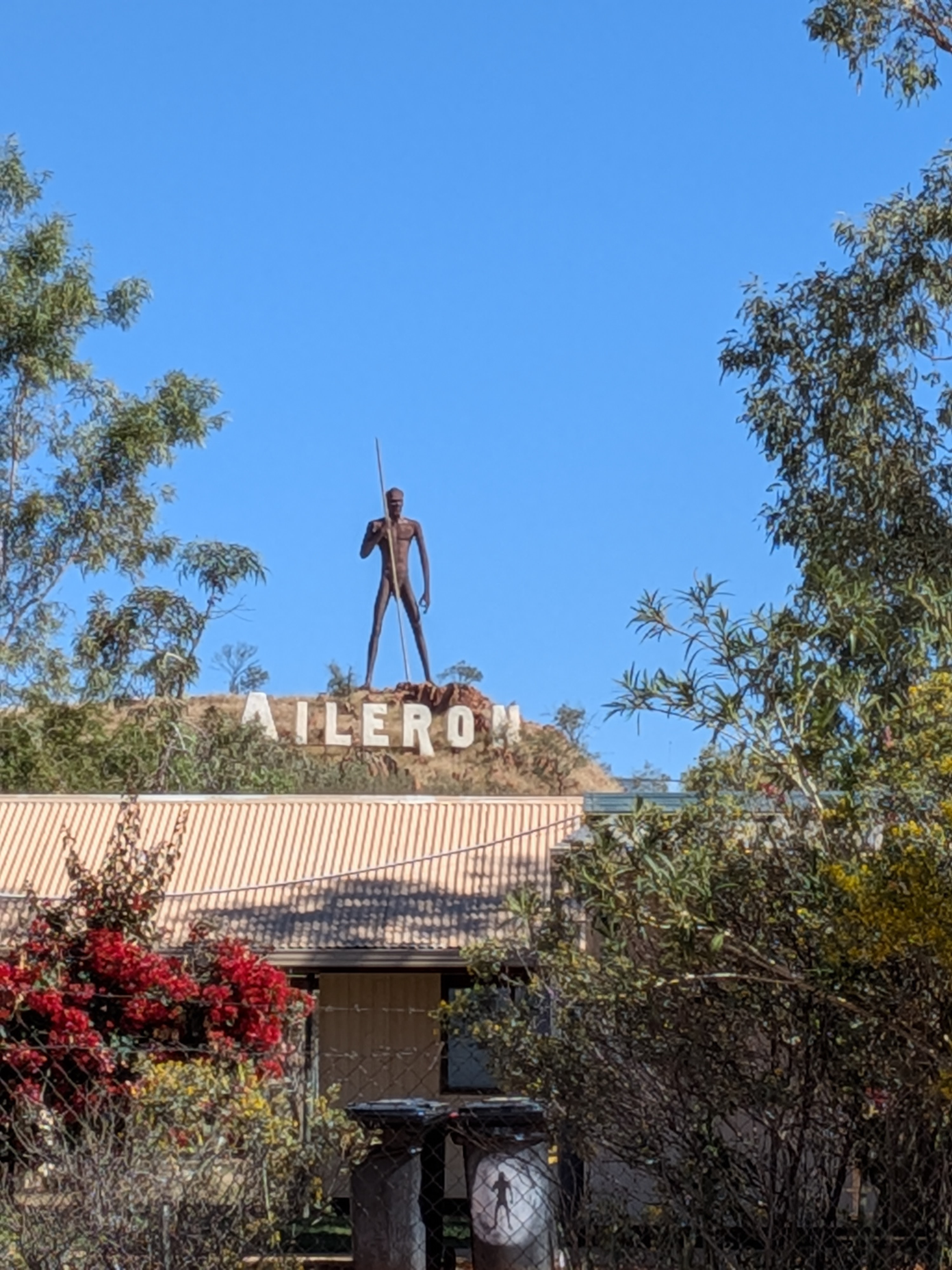 The Anmatjere Man statue holding a spear on the hill above the Aileron Roadhouse