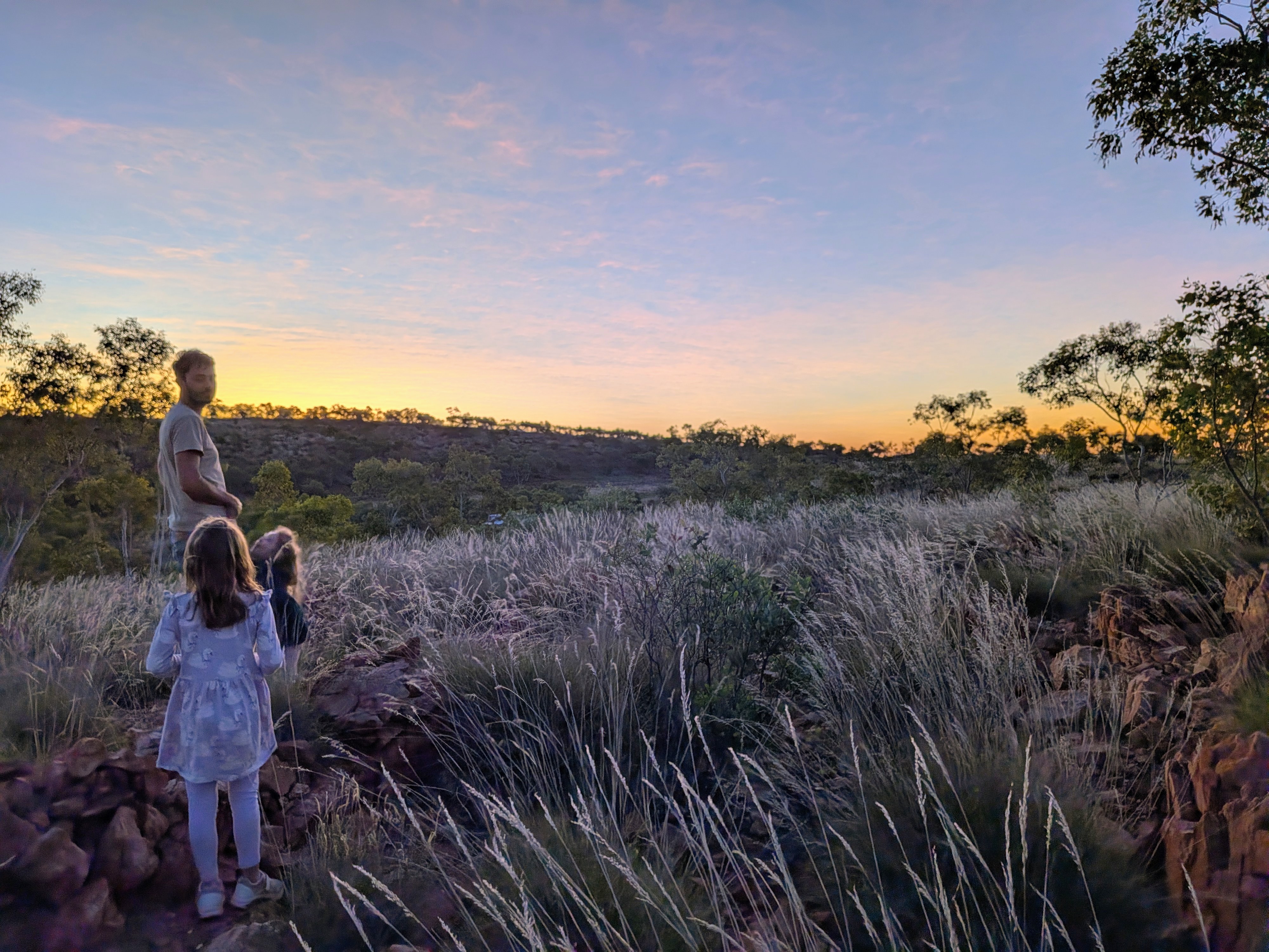Dylan and the girls looking out over the valley from the top of the hill at dusk
