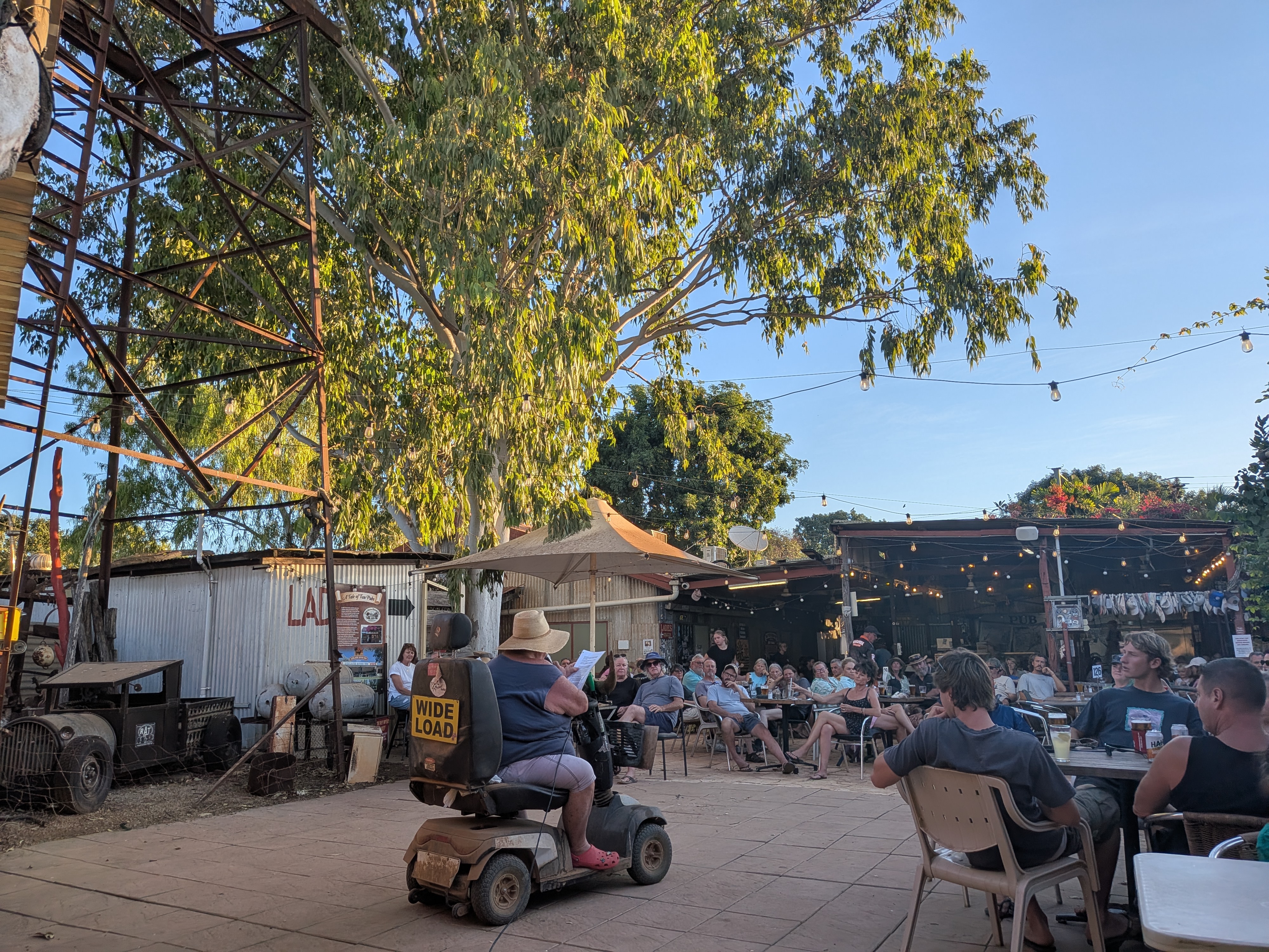 Tim cruising past the crowd on his mobility scooter with its WIDE LOAD sticker