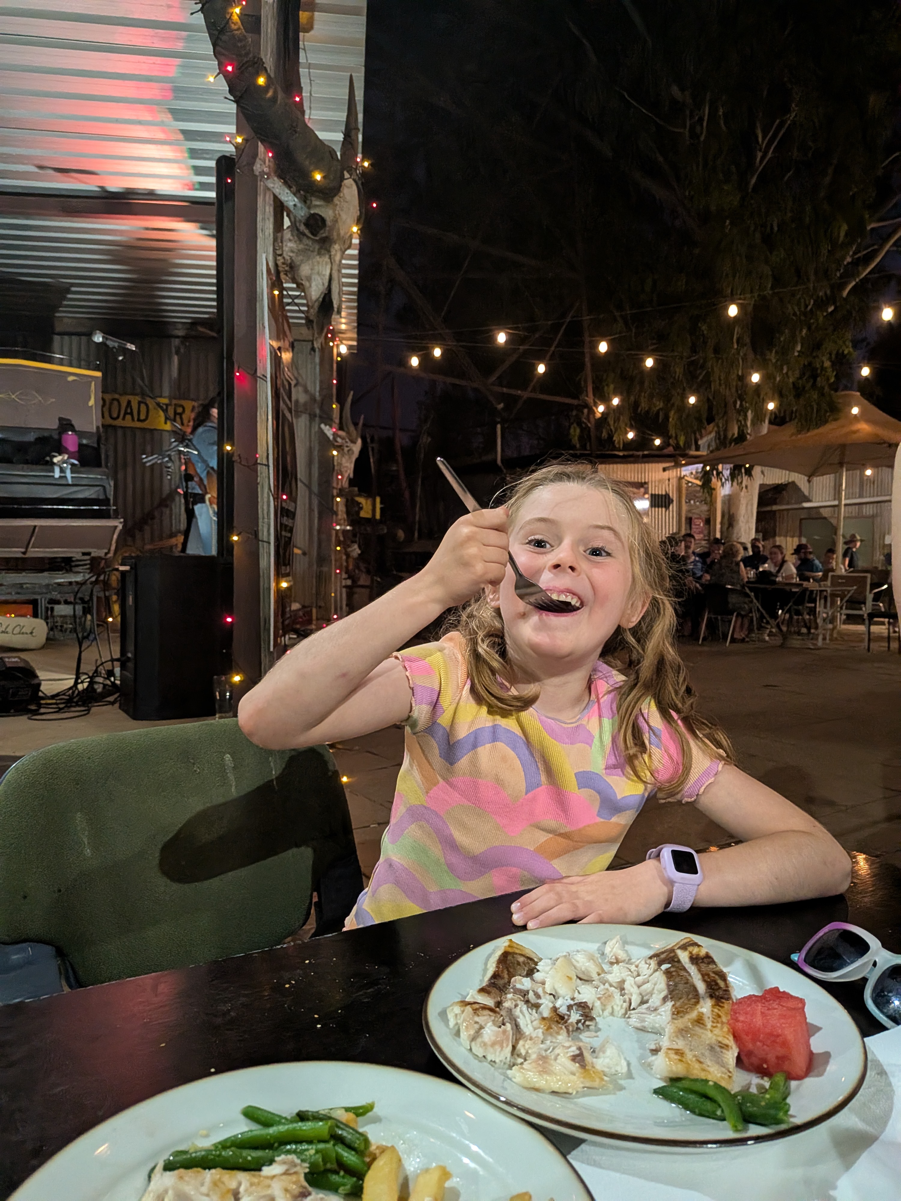 Hazel tucking into the barra under the fairy lights on Beef and Barra night