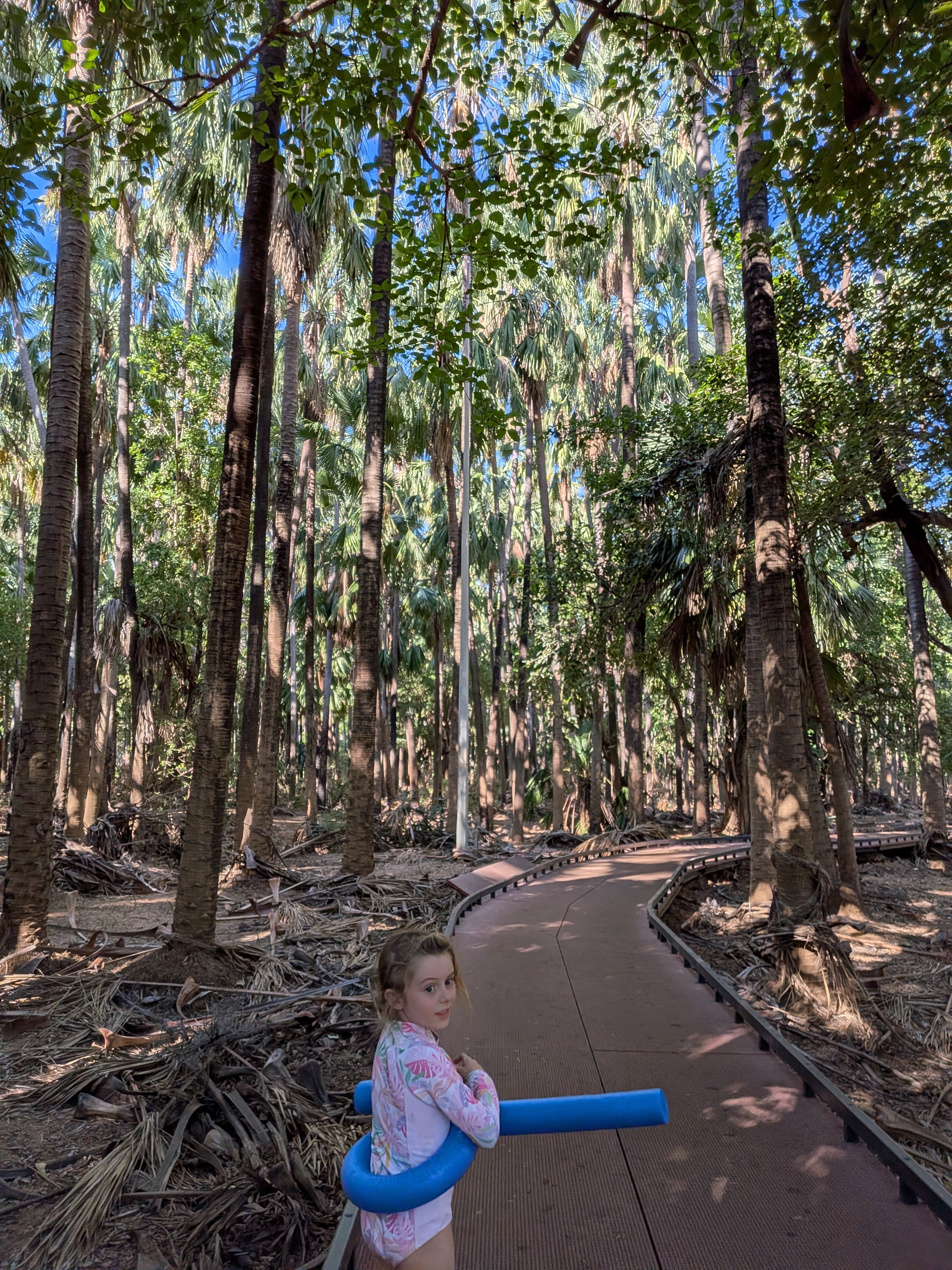 Hazel with her pool noodle on the boardwalk through the palm forest at Mataranka