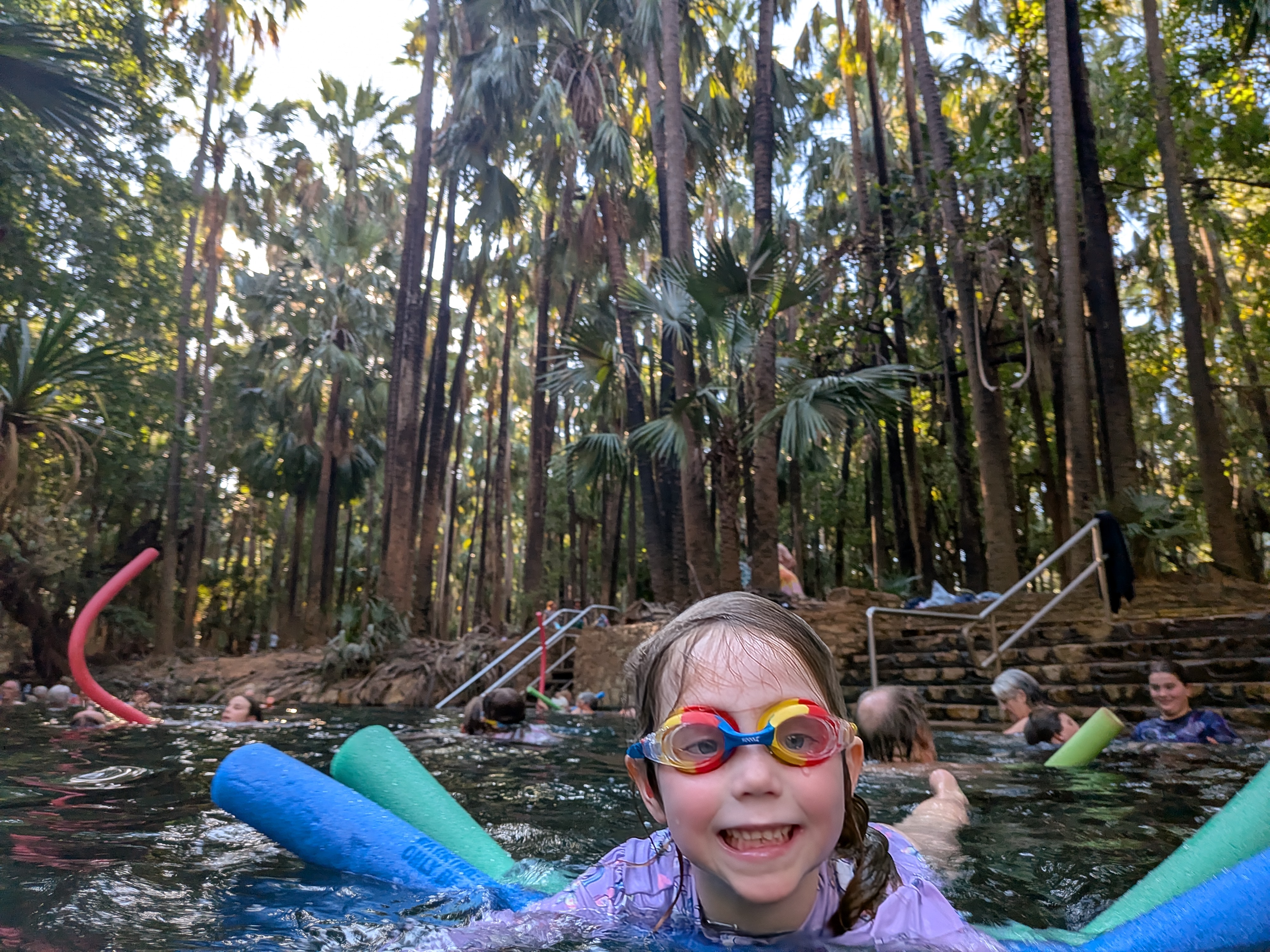 Leah beaming in her rainbow goggles in the warm water