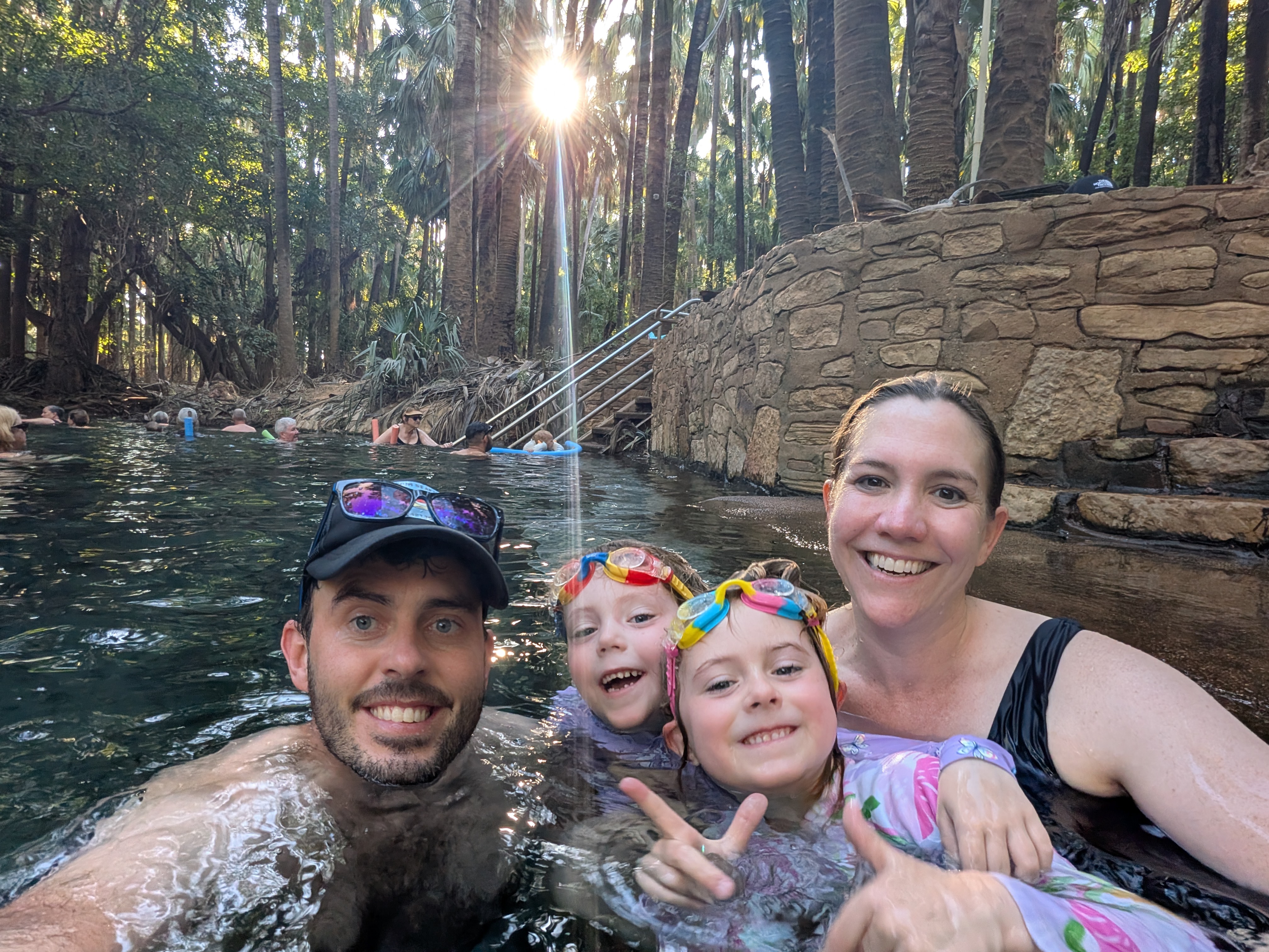Family selfie in the thermal pool with the sun bursting through the palms