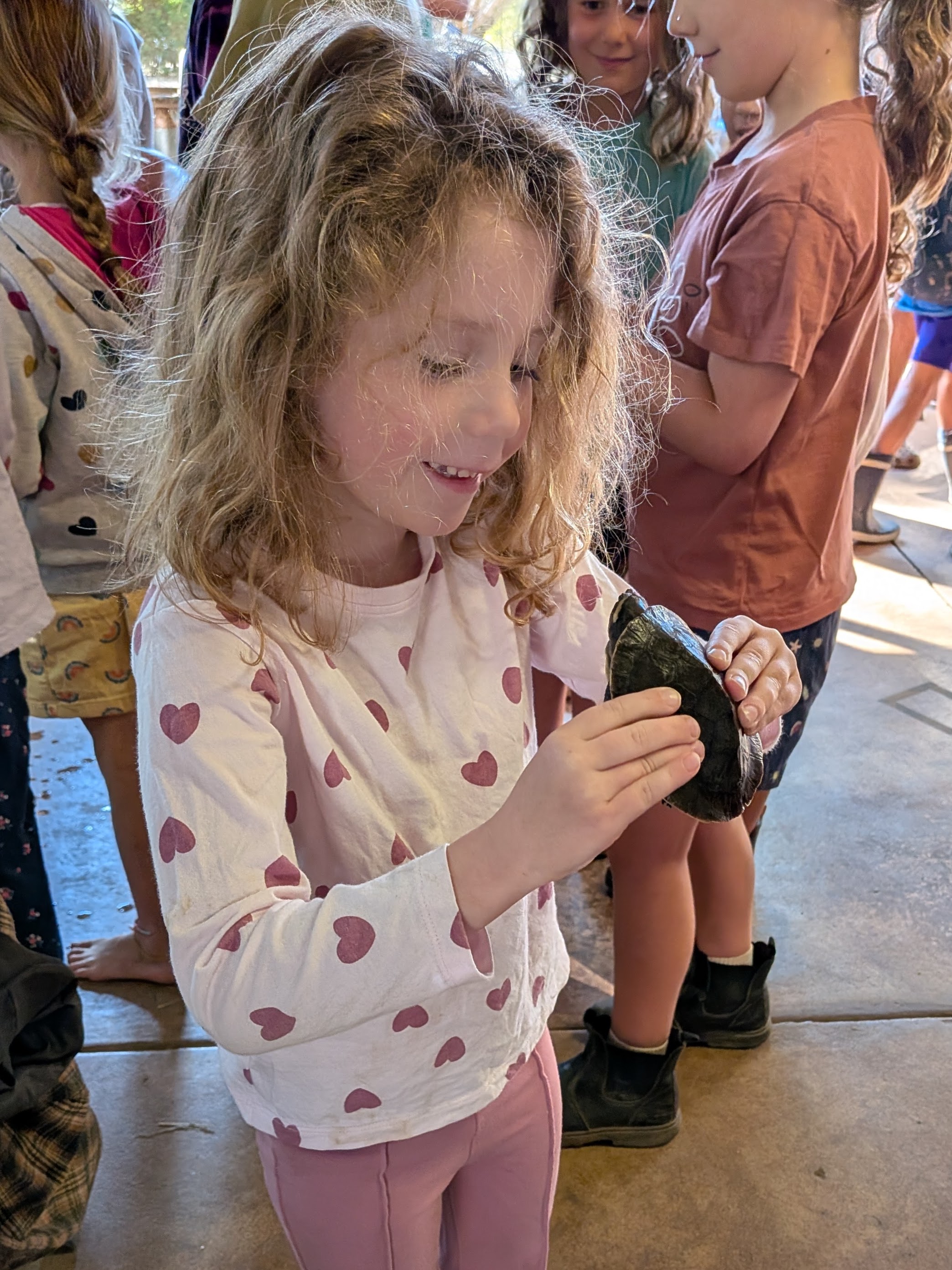 Leah smiling down at the turtle she's holding in the reptile house