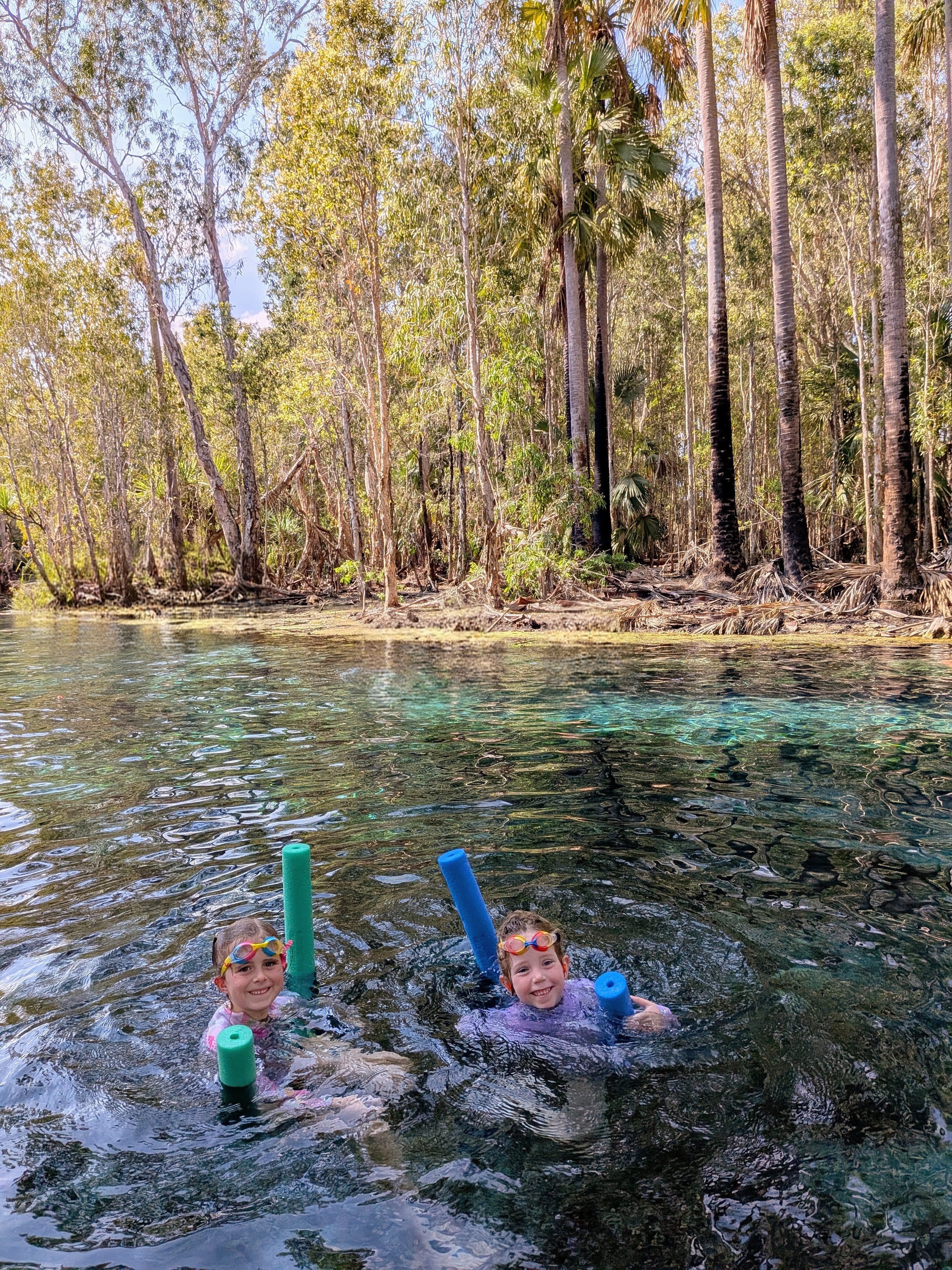 Hazel and Leah floating along Bitter Springs with their noodles