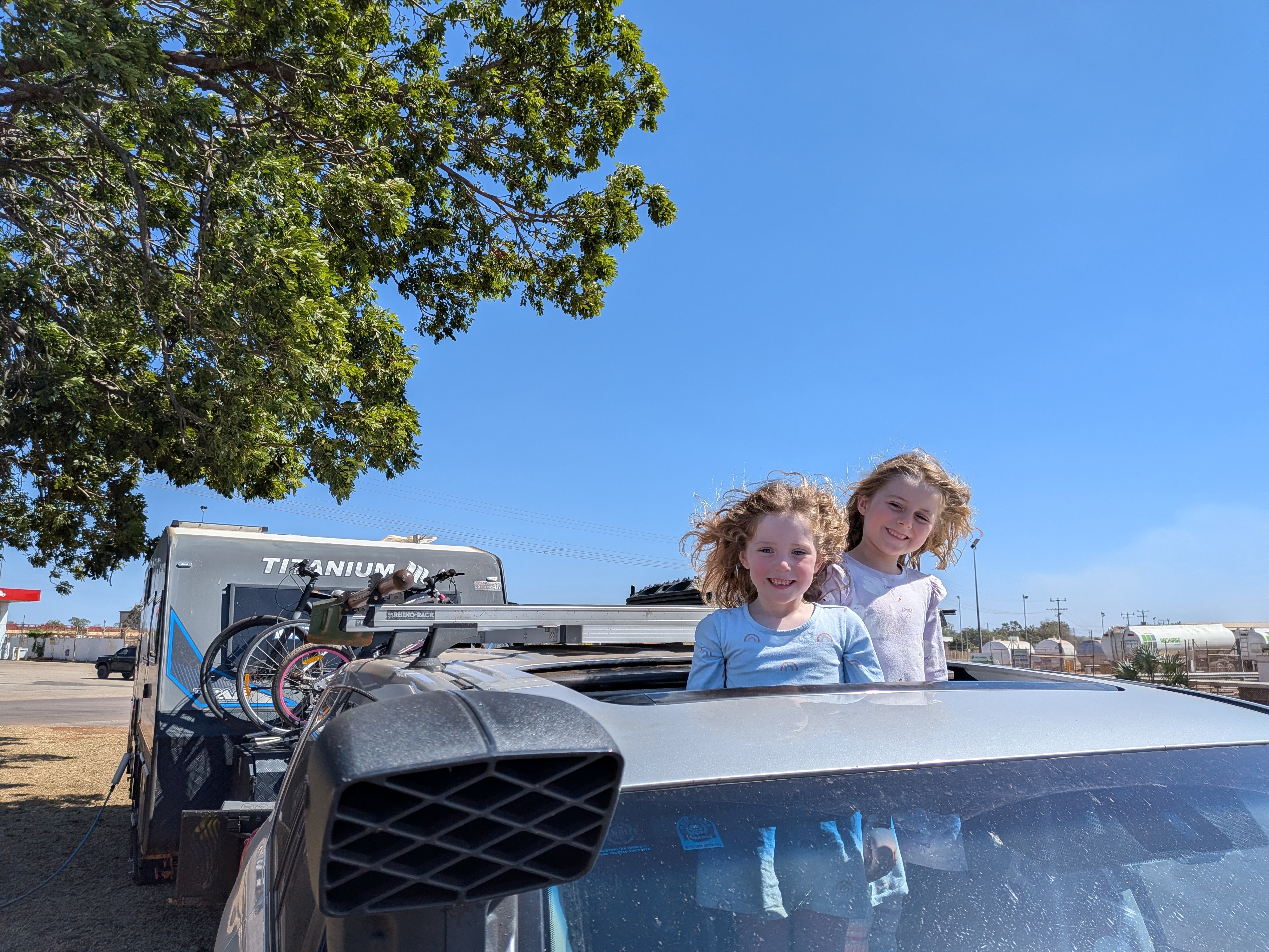 Hazel and Leah popped up through the car sunroof at the Katherine fuel stop