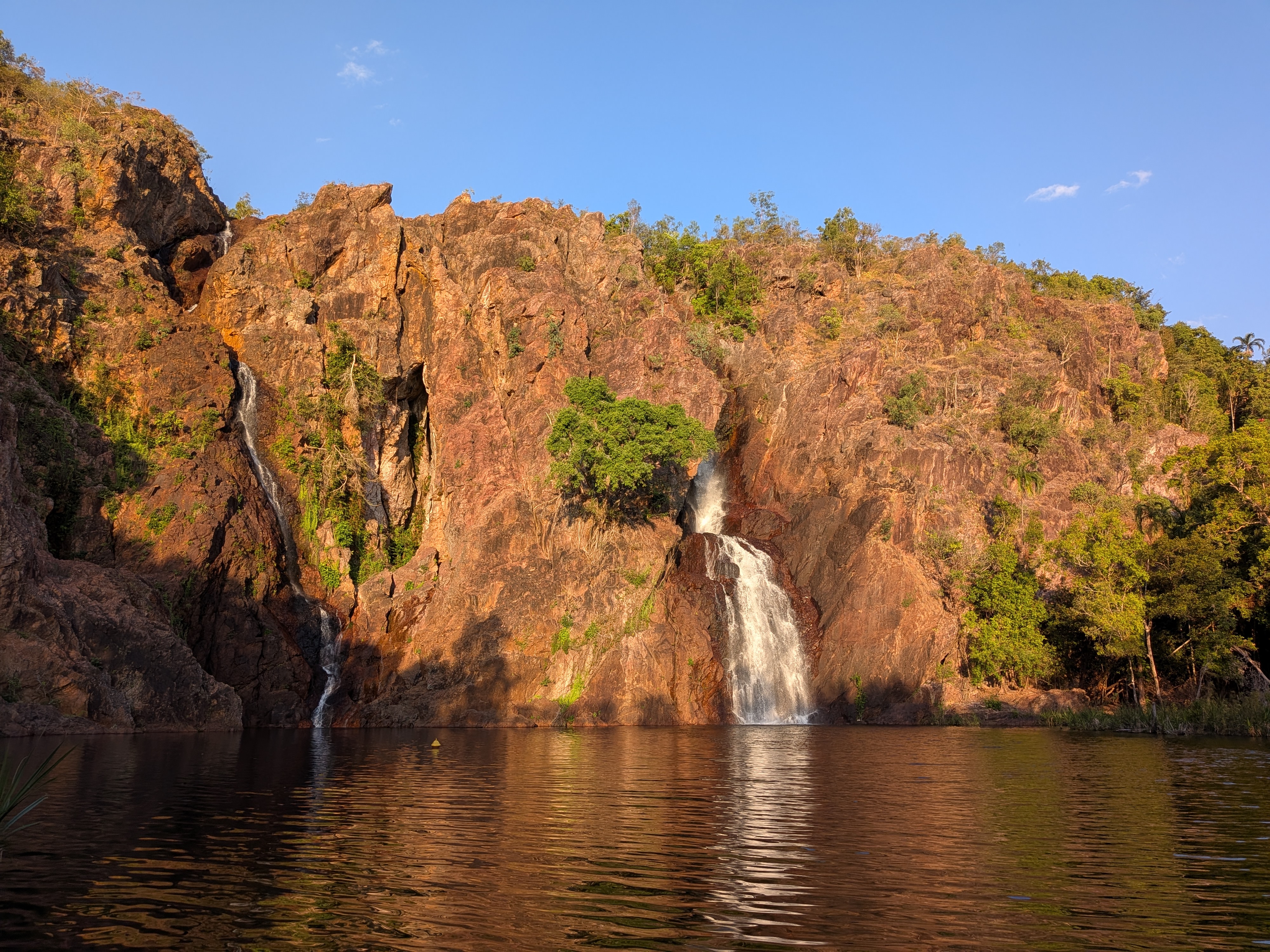 Wangi Falls in golden-hour light — both falls pouring into the still plunge pool