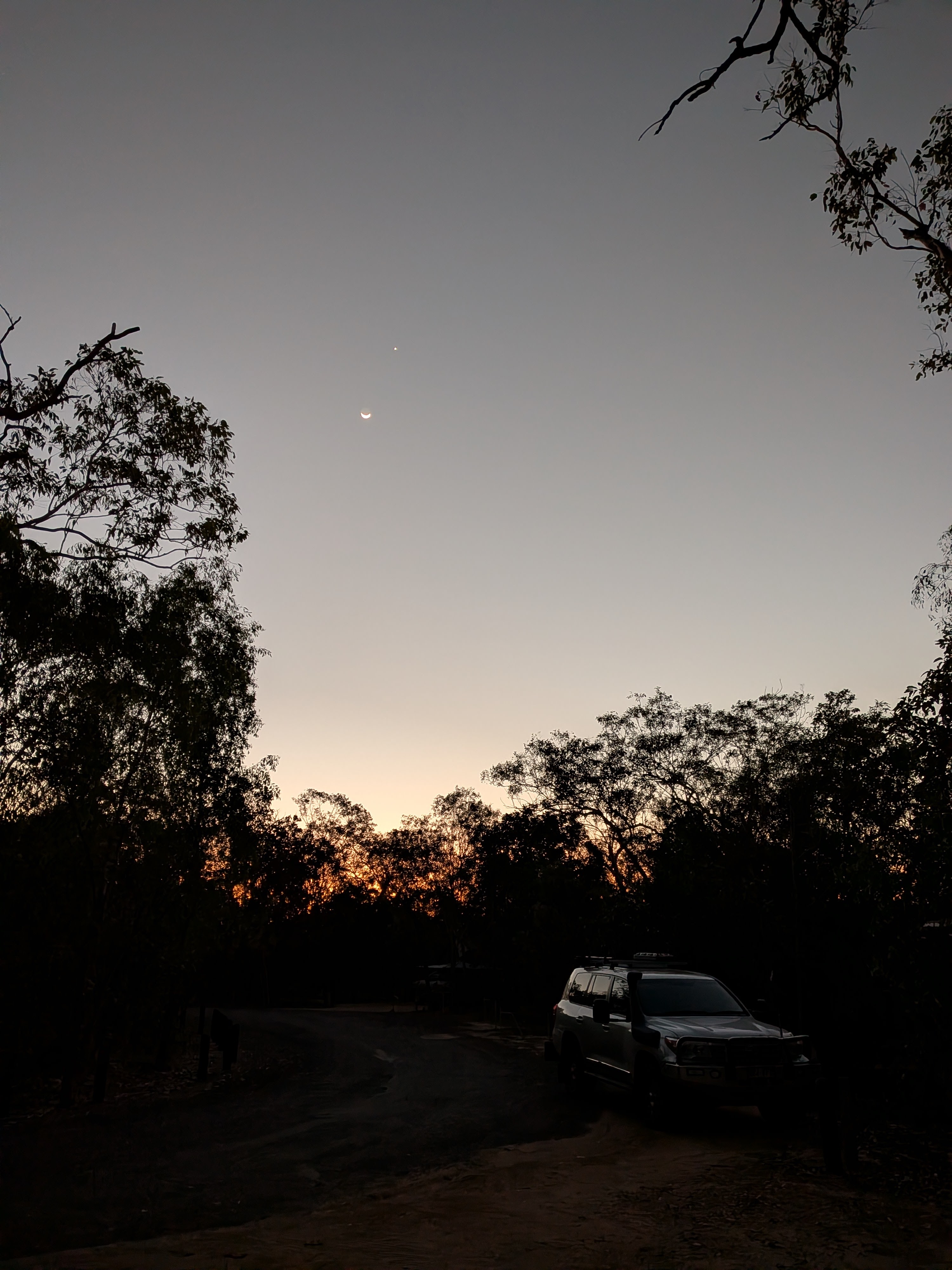 The crescent moon and Venus over the darkening campground