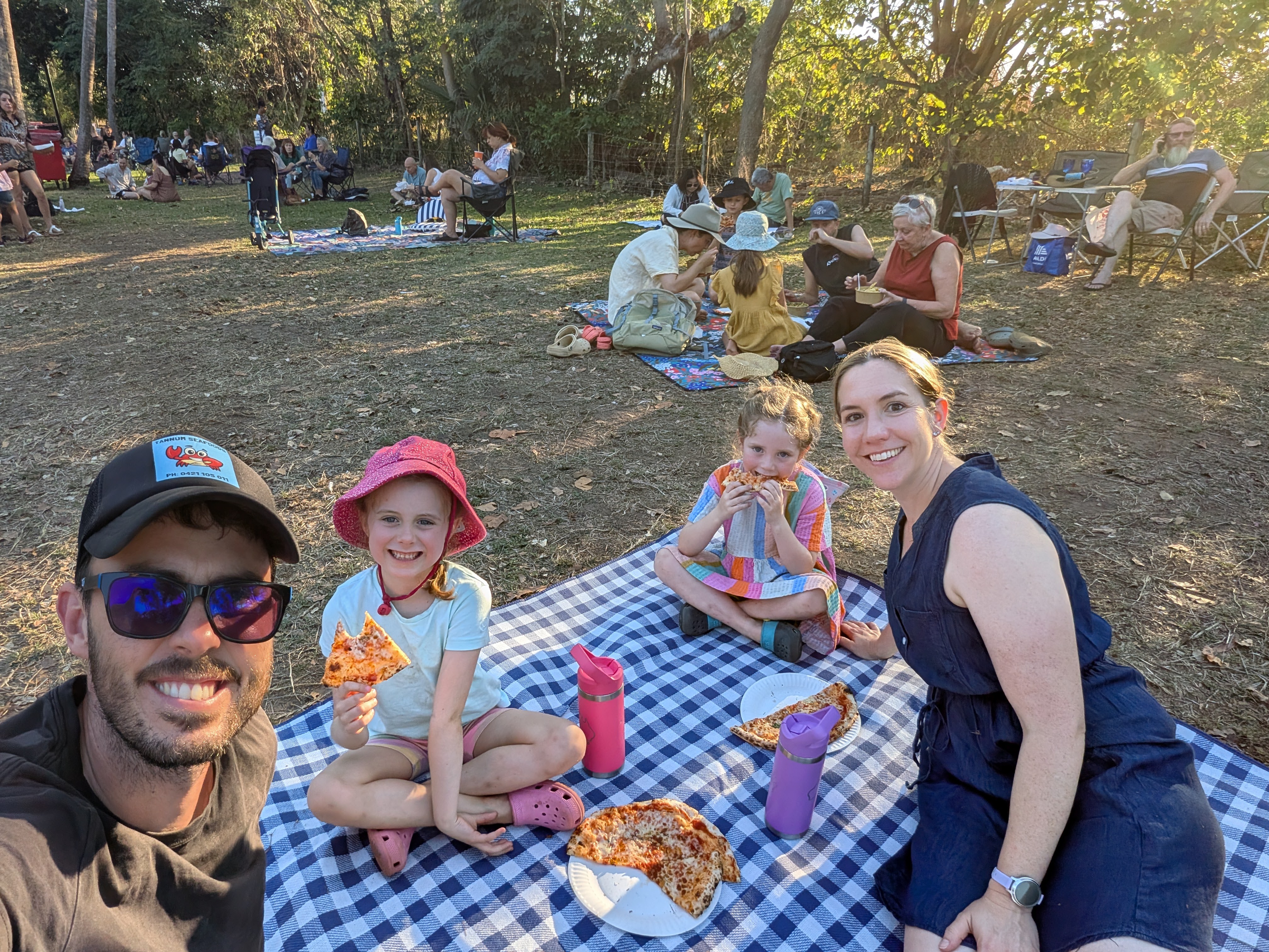 Family selfie on the picnic rug in the golden light at the Mindil Beach Sunset Markets
