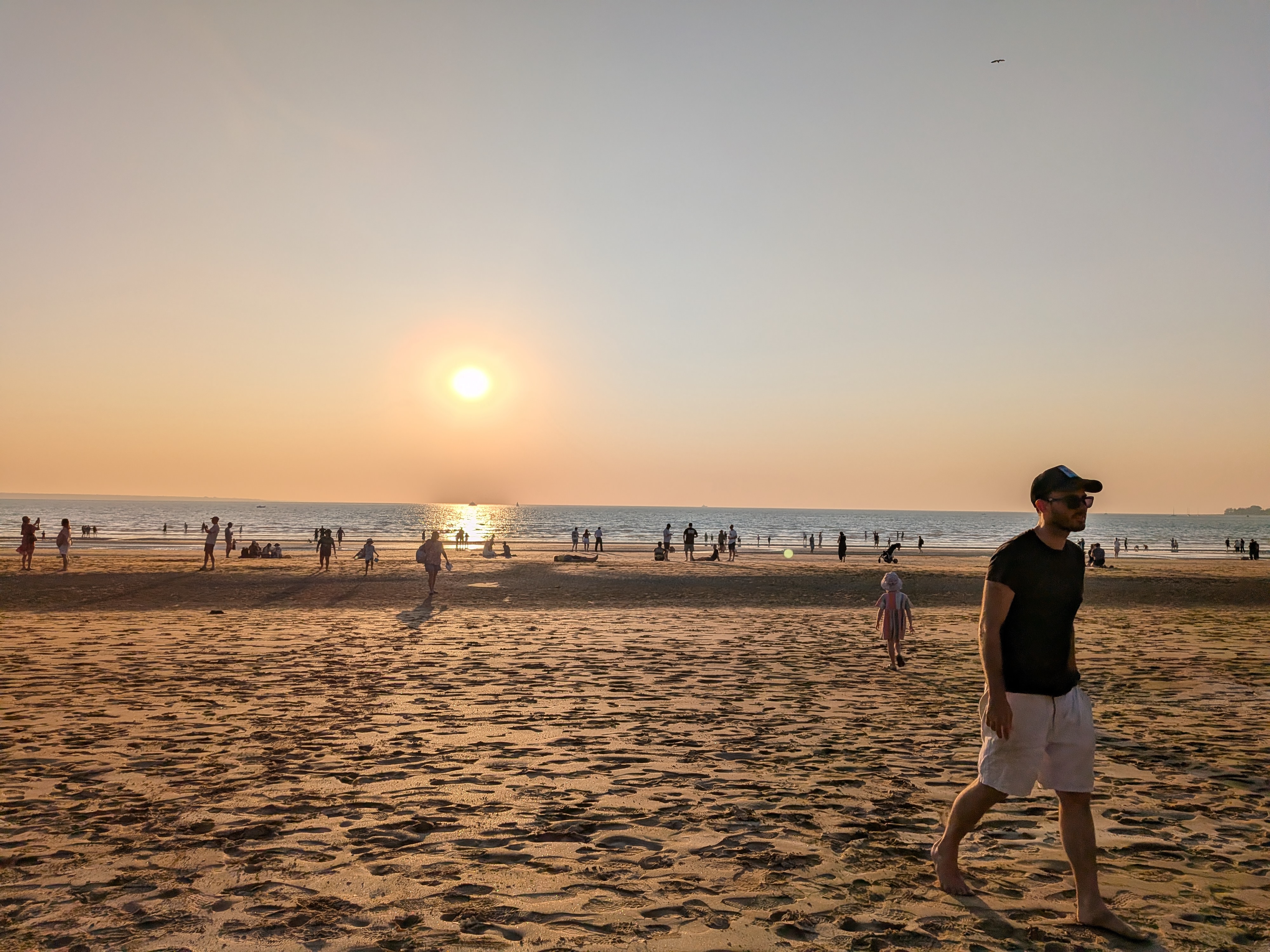 Dylan strolling along Mindil Beach as the sun drops towards the water