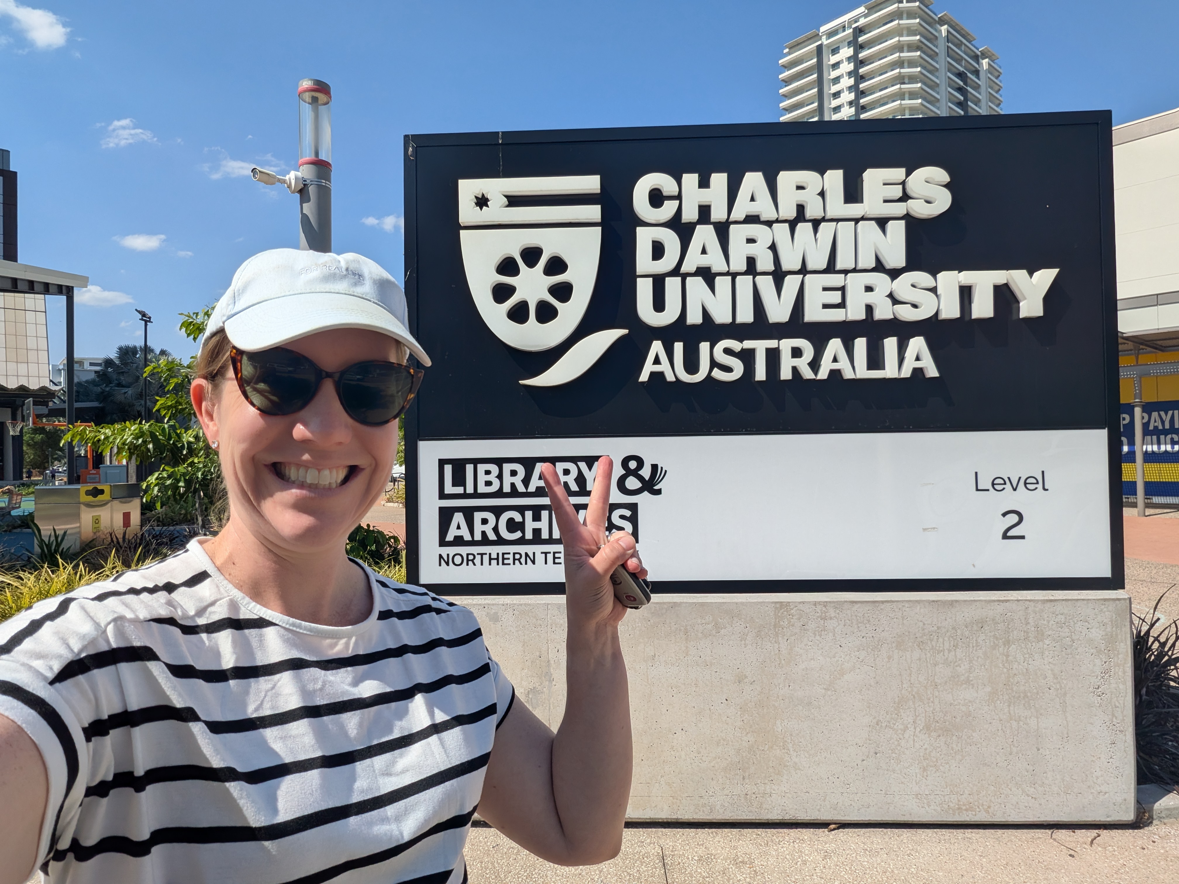 Erin outside the Charles Darwin University sign in the city