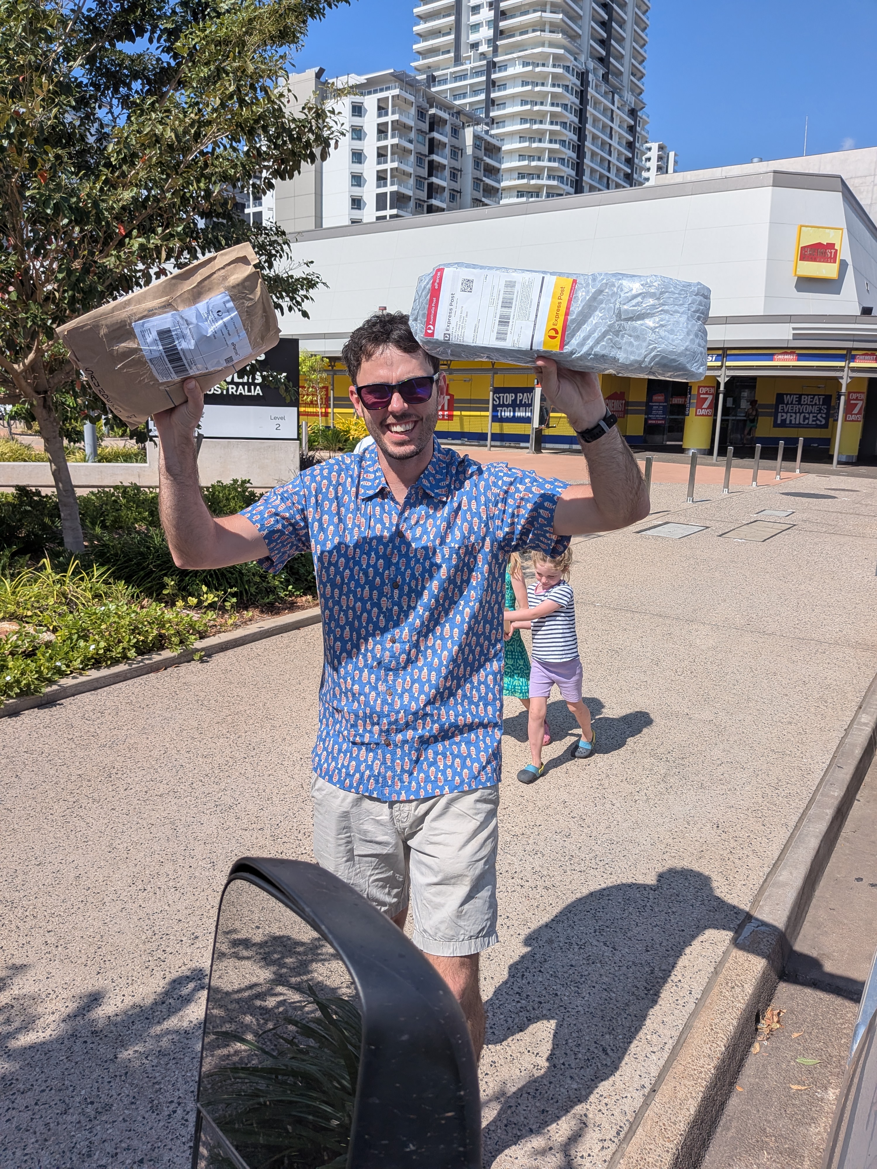 Dylan holding the parcels aloft outside Charles Darwin University &mdash; the Gameboys have landed
