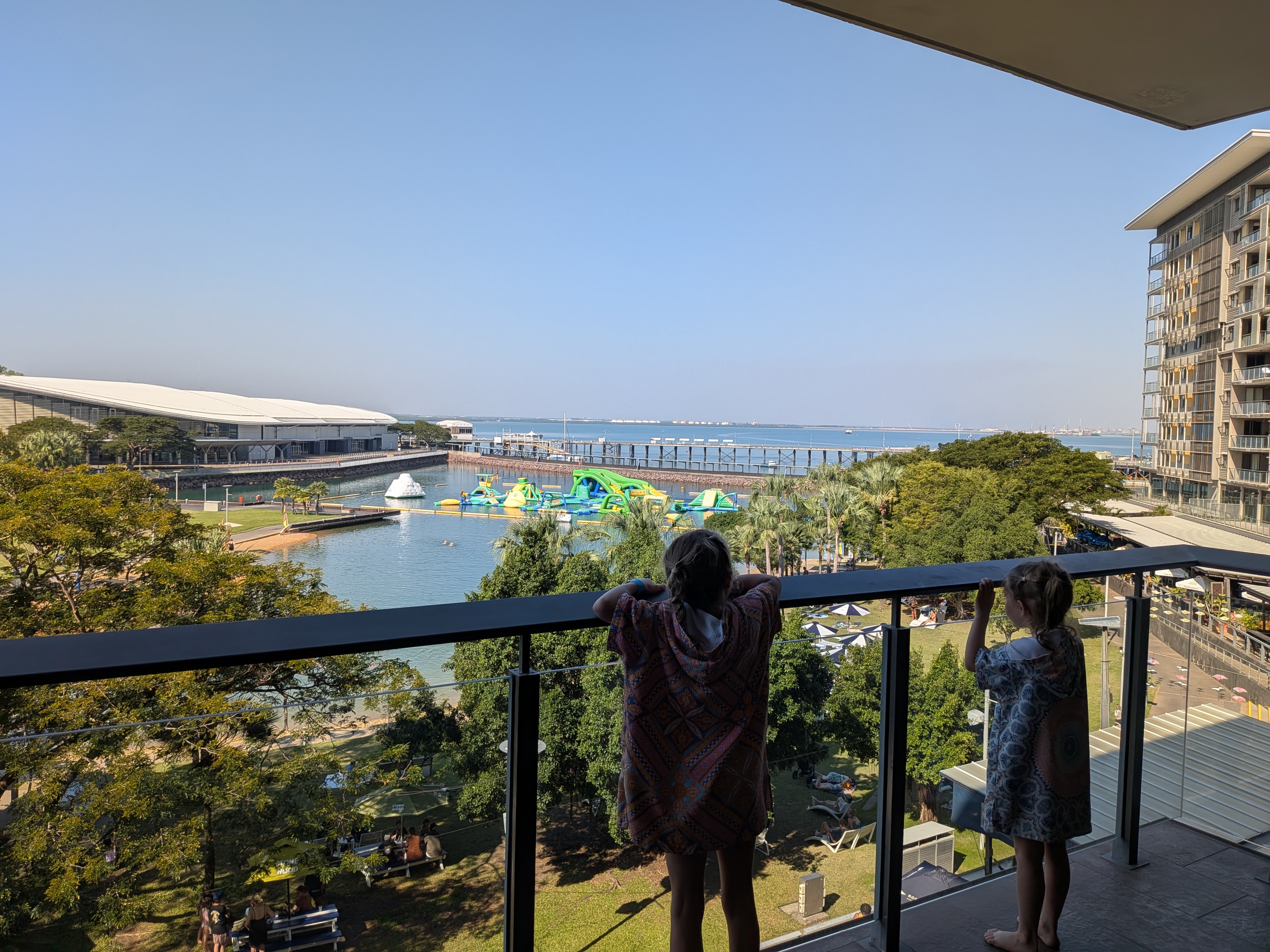 The view from our apartment balcony &mdash; Hazel and Leah in their swim ponchos surveying the Wave Lagoon and Aqua Park below