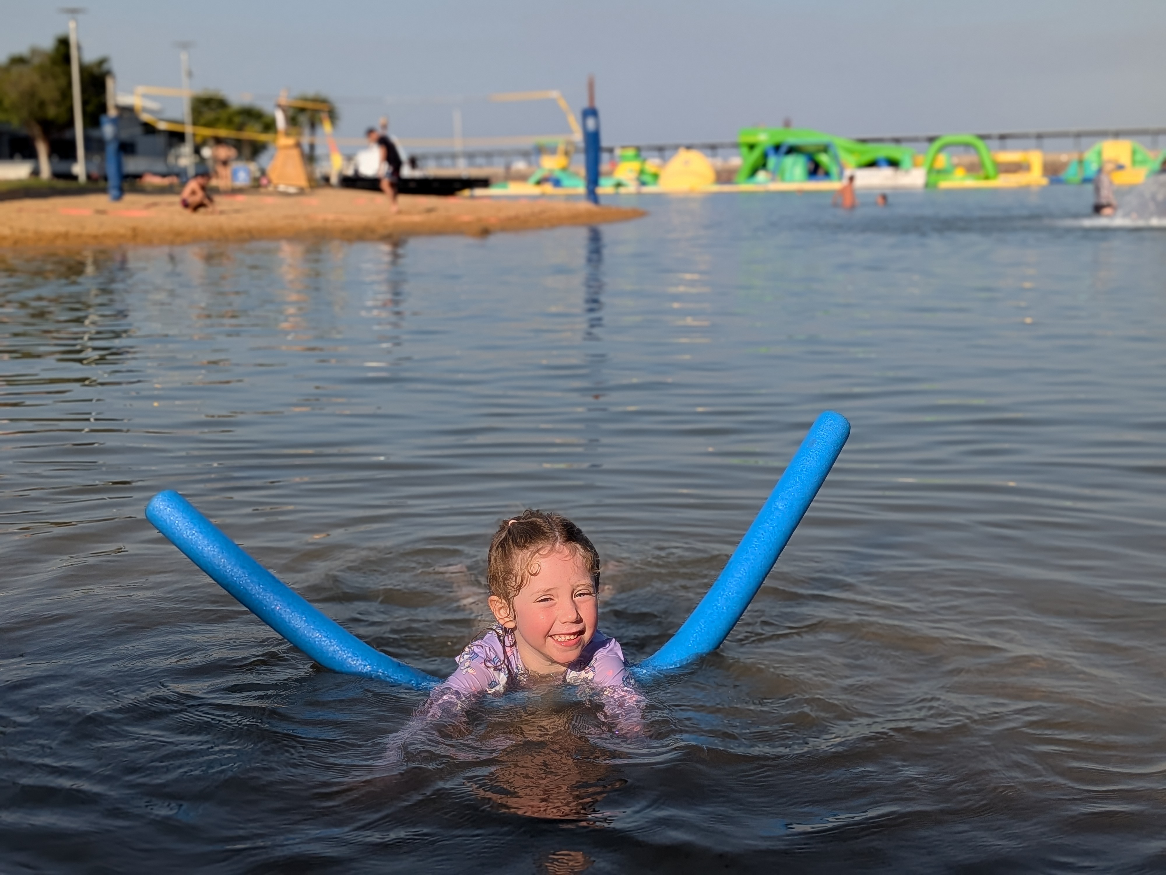 Leah and her noodle in the swimming lagoon at the Darwin Waterfront