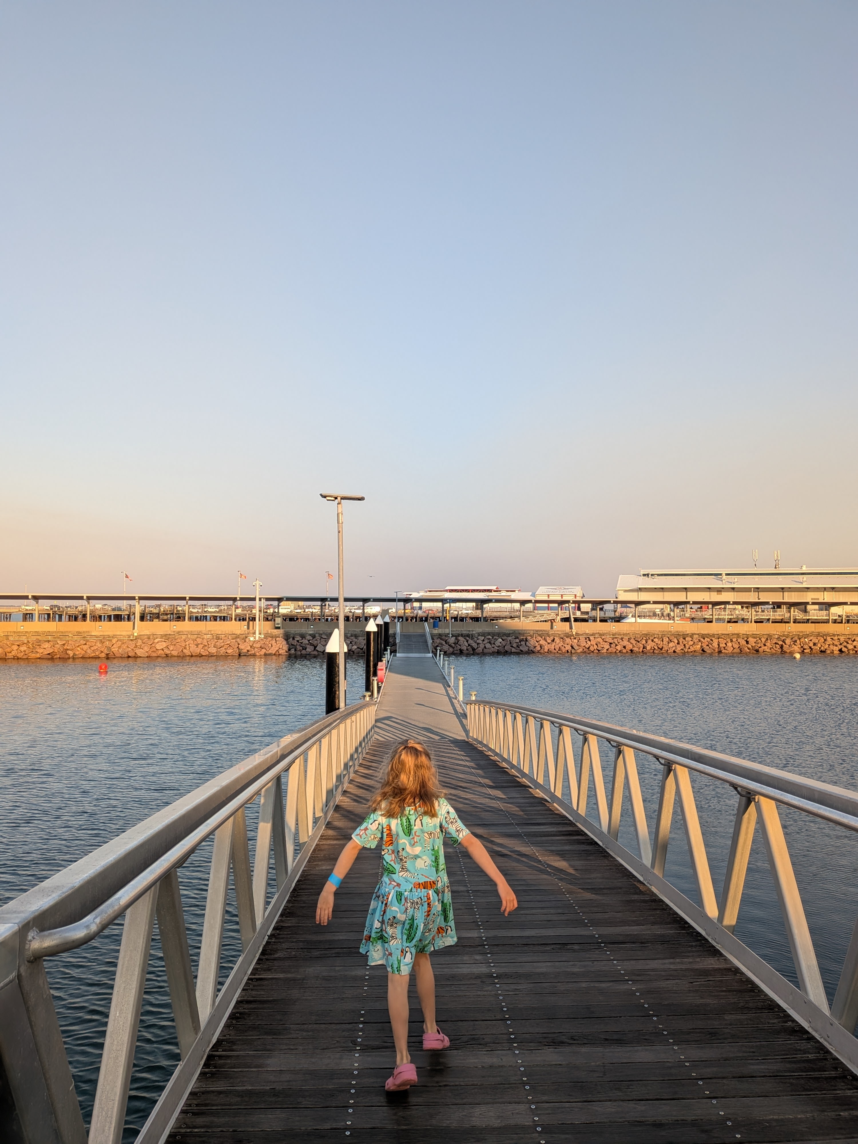 Leah leading the way across the footbridge to Stokes Hill Wharf at golden hour