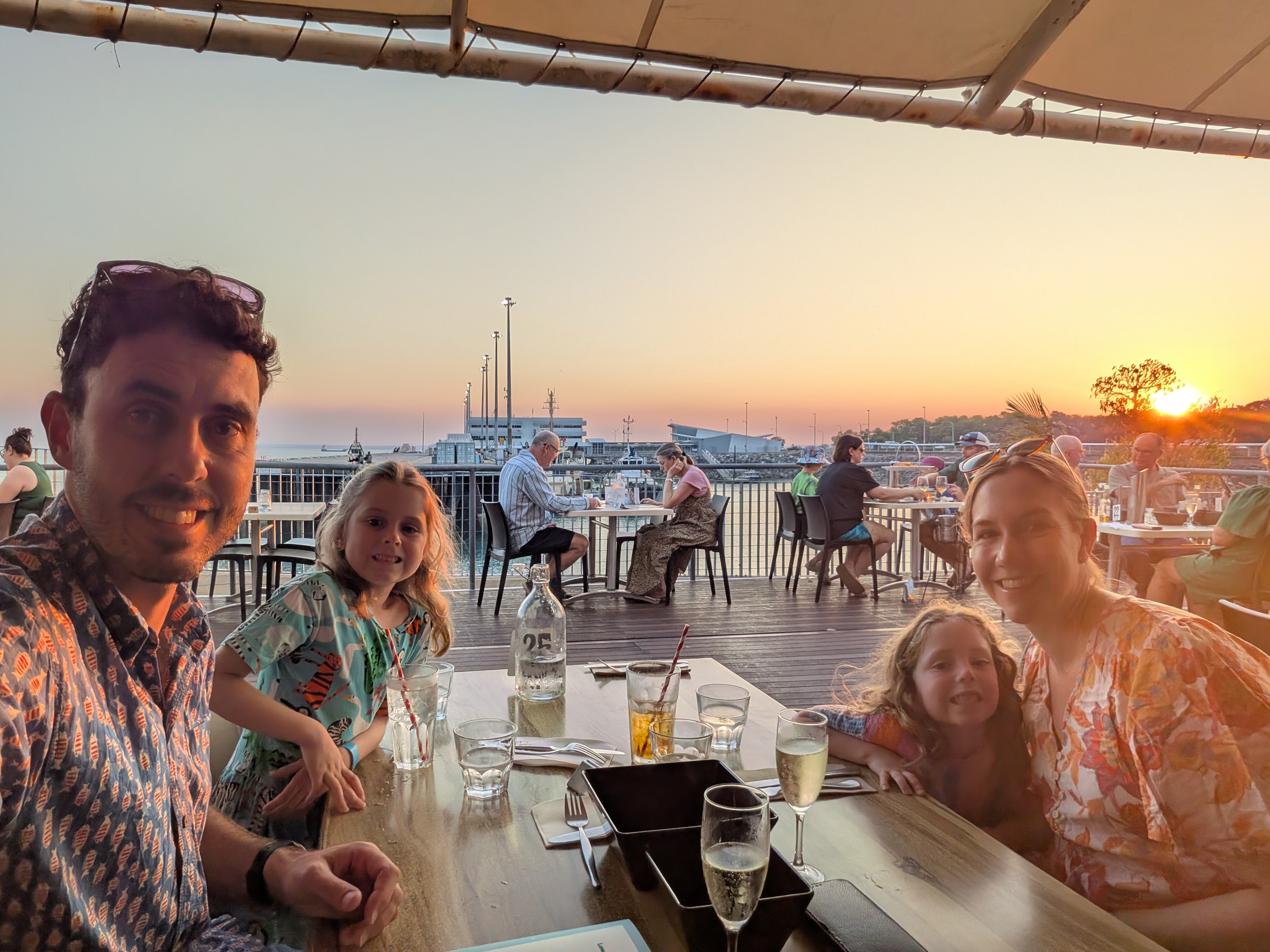 Family selfie at our Stokes Hill Wharf dinner table as the sun sets behind us