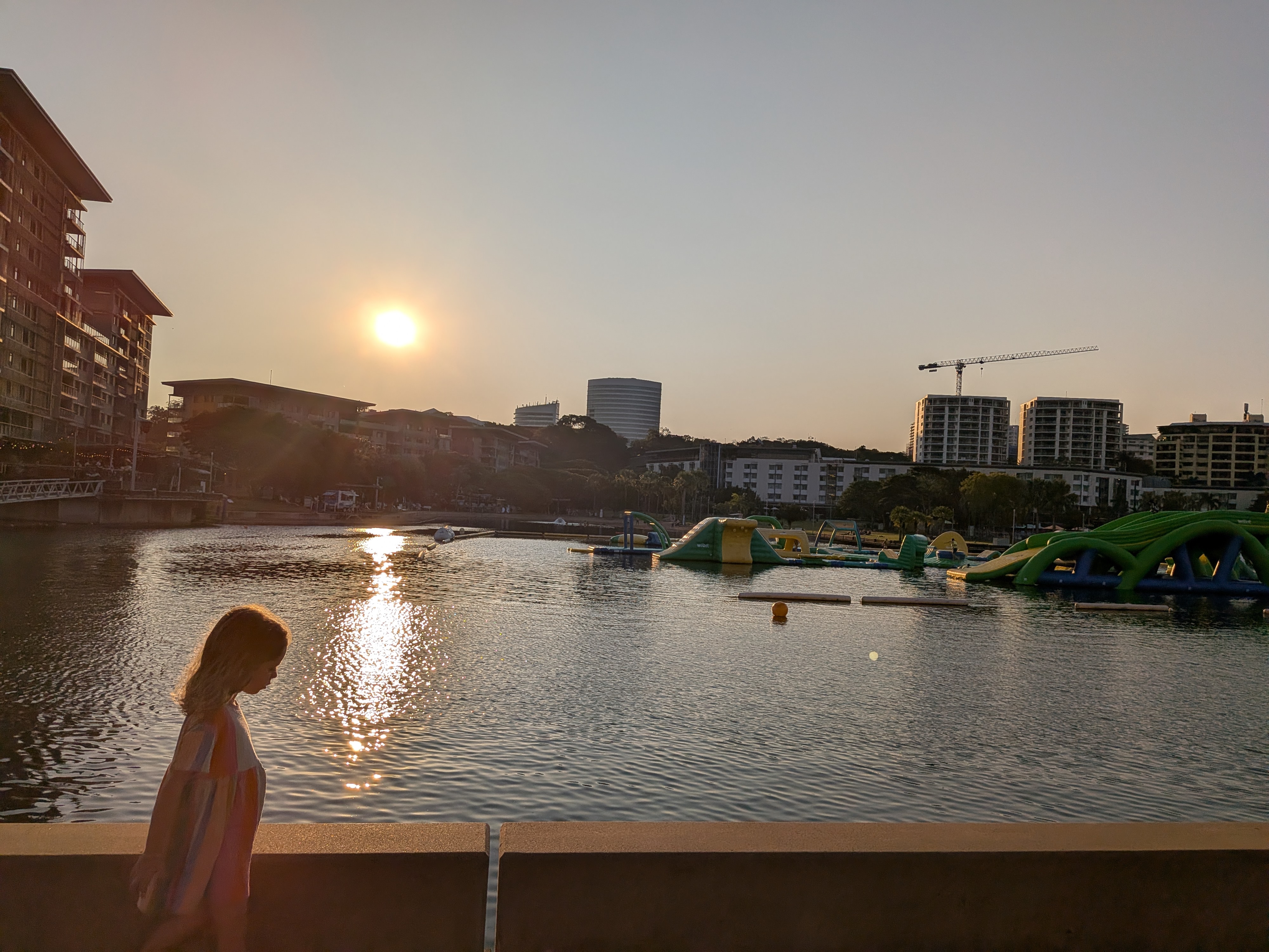 Leah silhouetted against the sunset over the lagoon on the walk to dinner