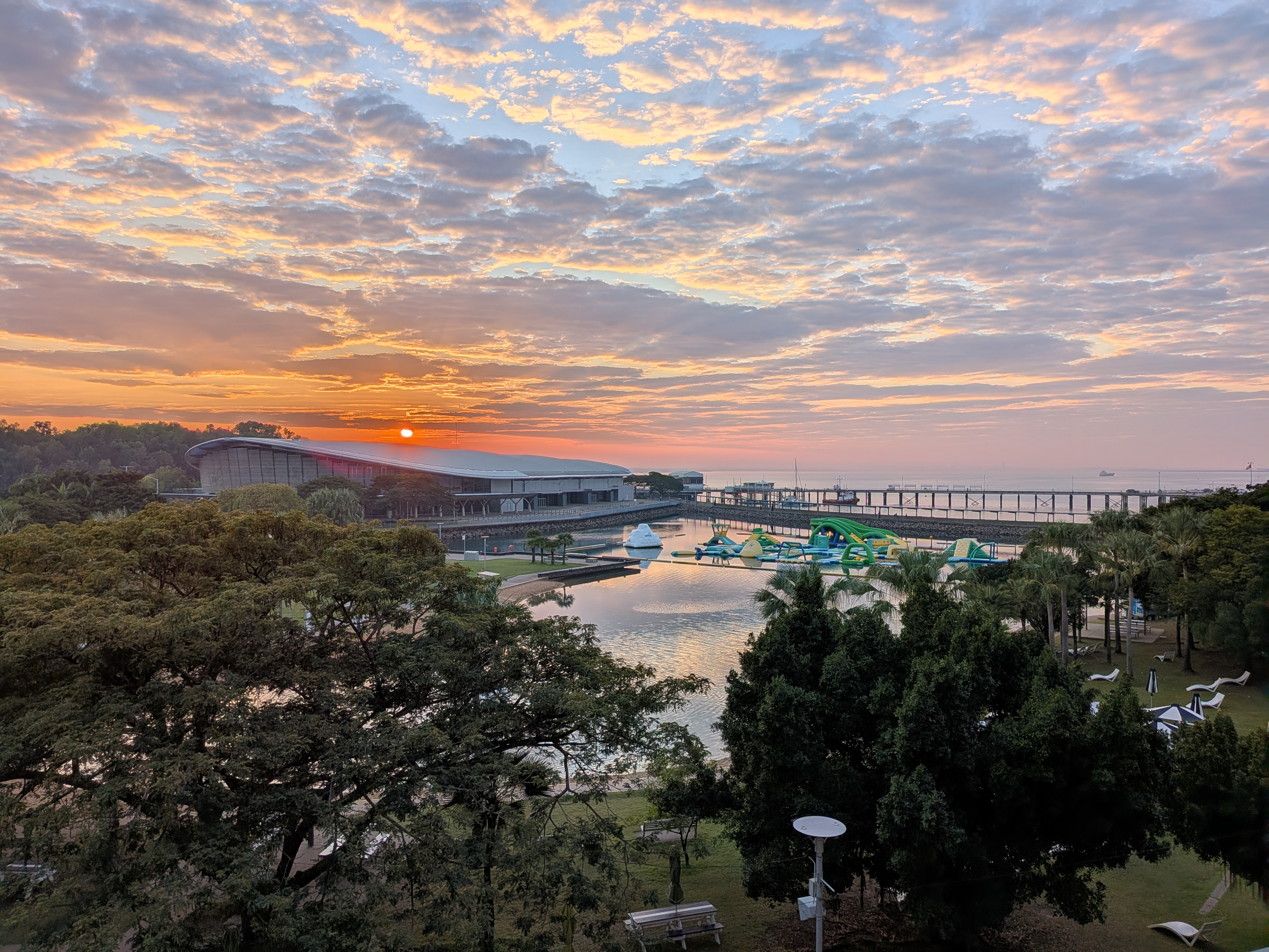 Sunrise over the Wave Lagoon and Stokes Hill Wharf from the apartment balcony &mdash; one last Darwin view before checkout