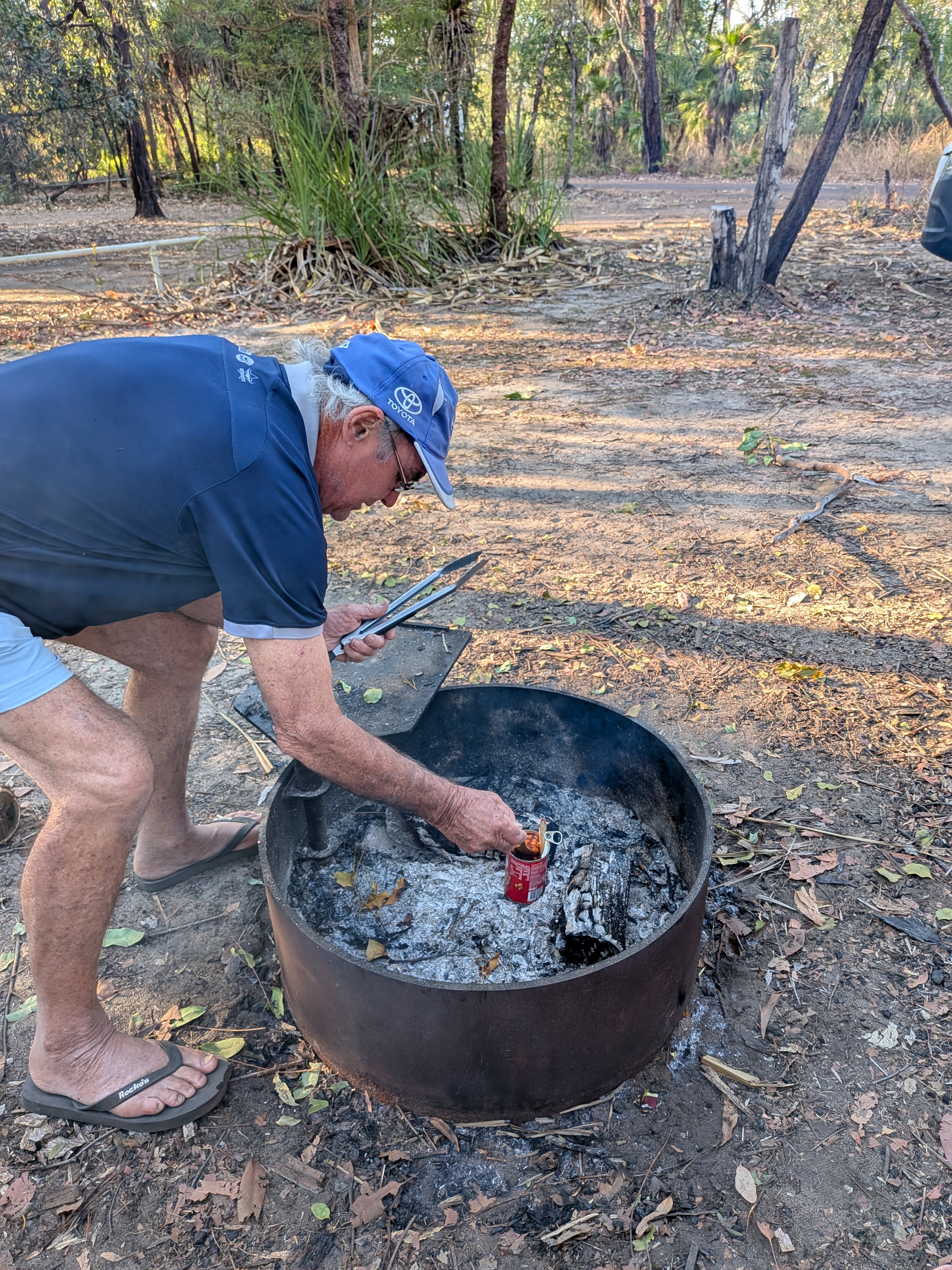 Pa warming a tin of beans on the fire at Merl campground