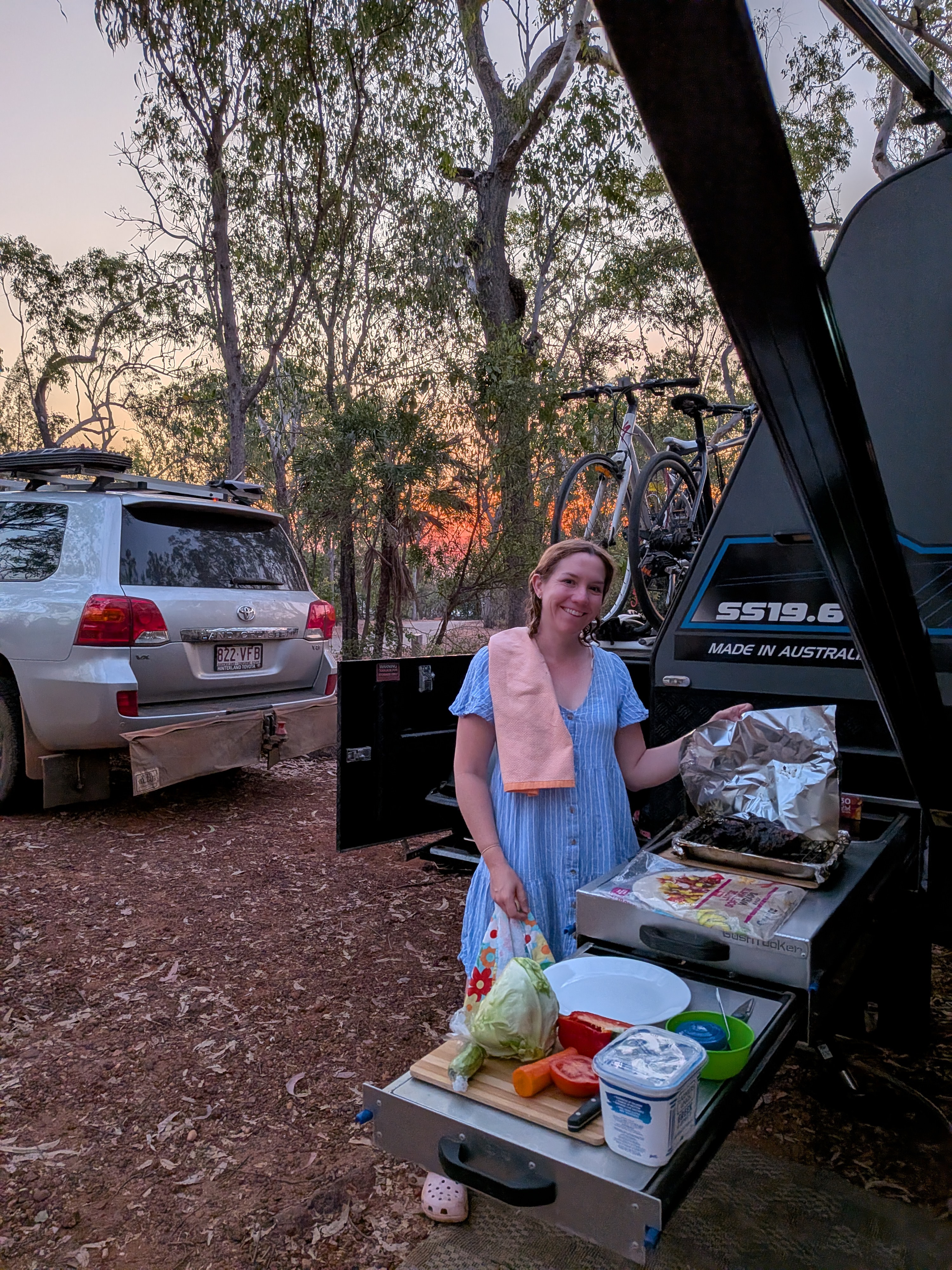 Erin at the slide-out kitchen, butterflied lamb headed for the BabyQ as the sun sets