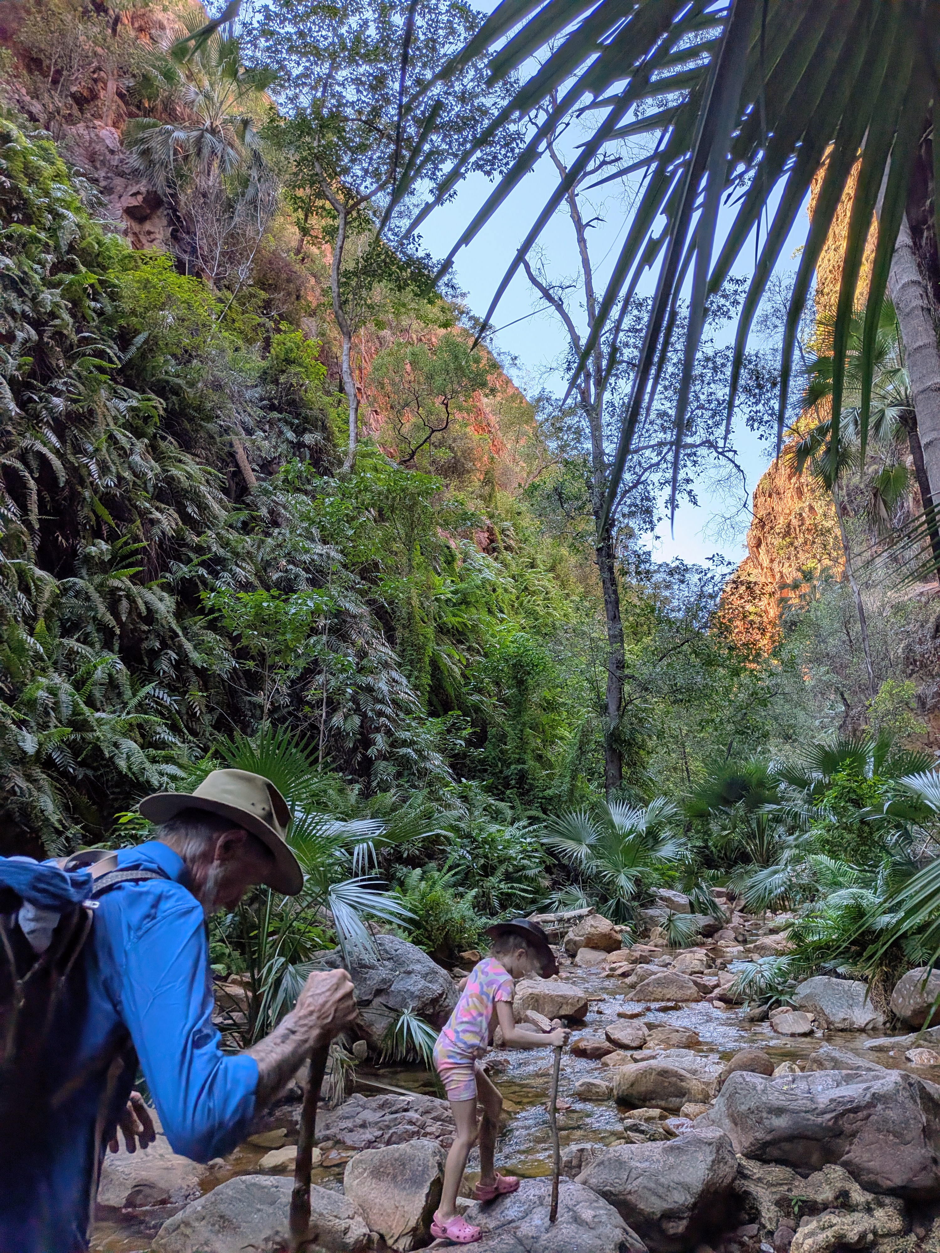 Gordon and Hazel crossing the creek, walking sticks in hand