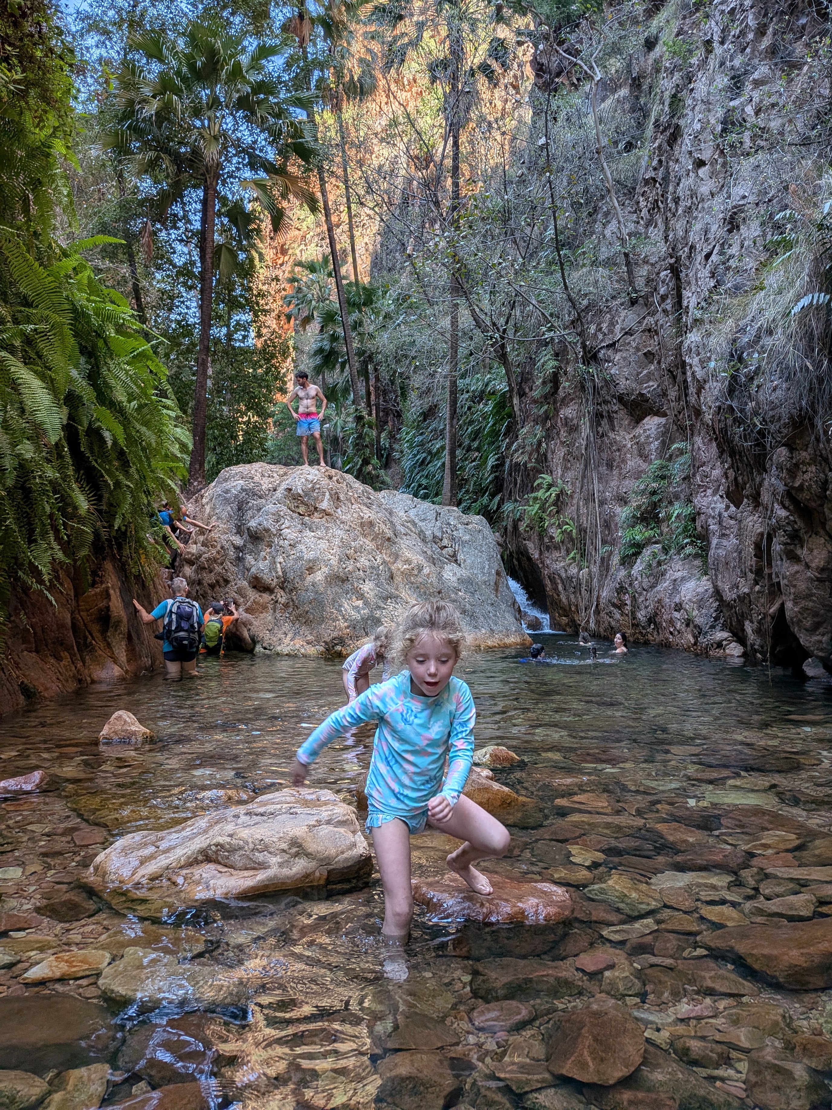 Arriving at the halfway pool &mdash; Leah wading in, Dylan already out on the boulder