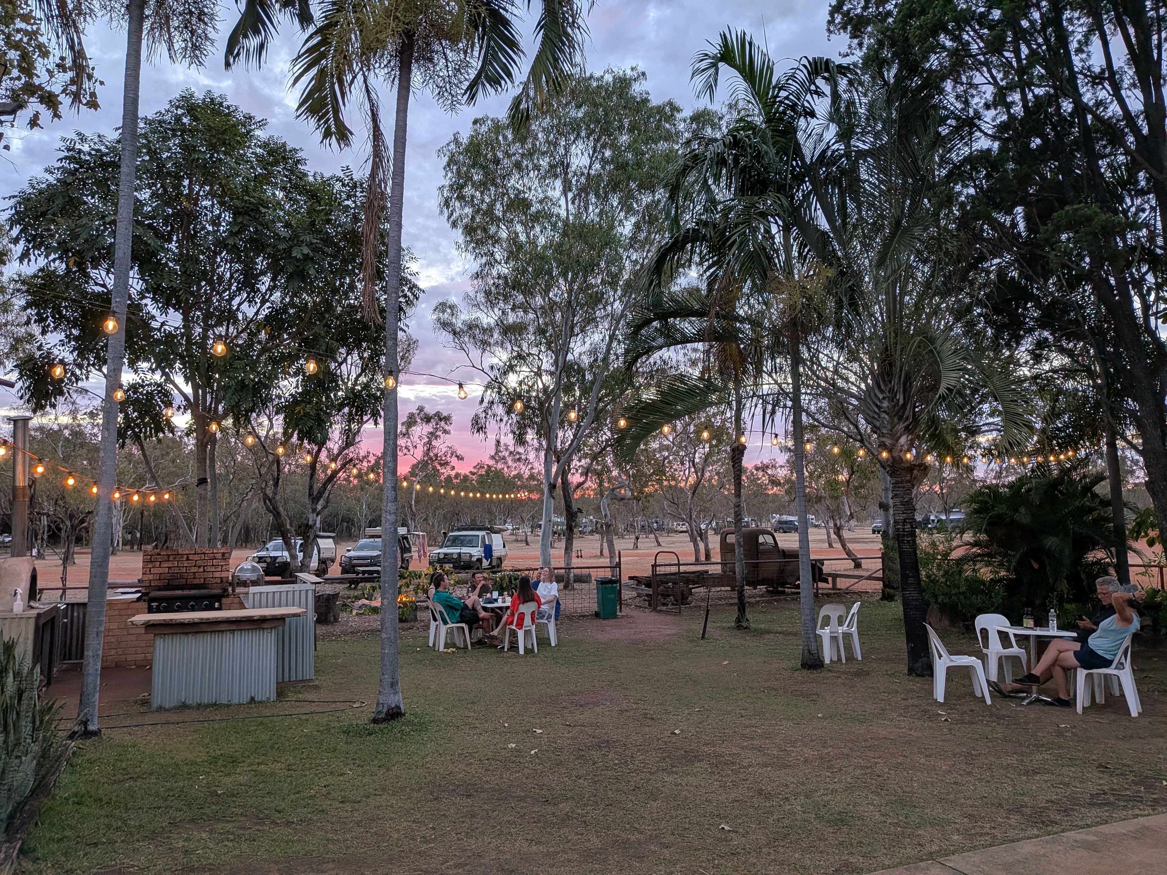 Beer o&rsquo;clock at the station &mdash; string lights and a pink Kimberley sky