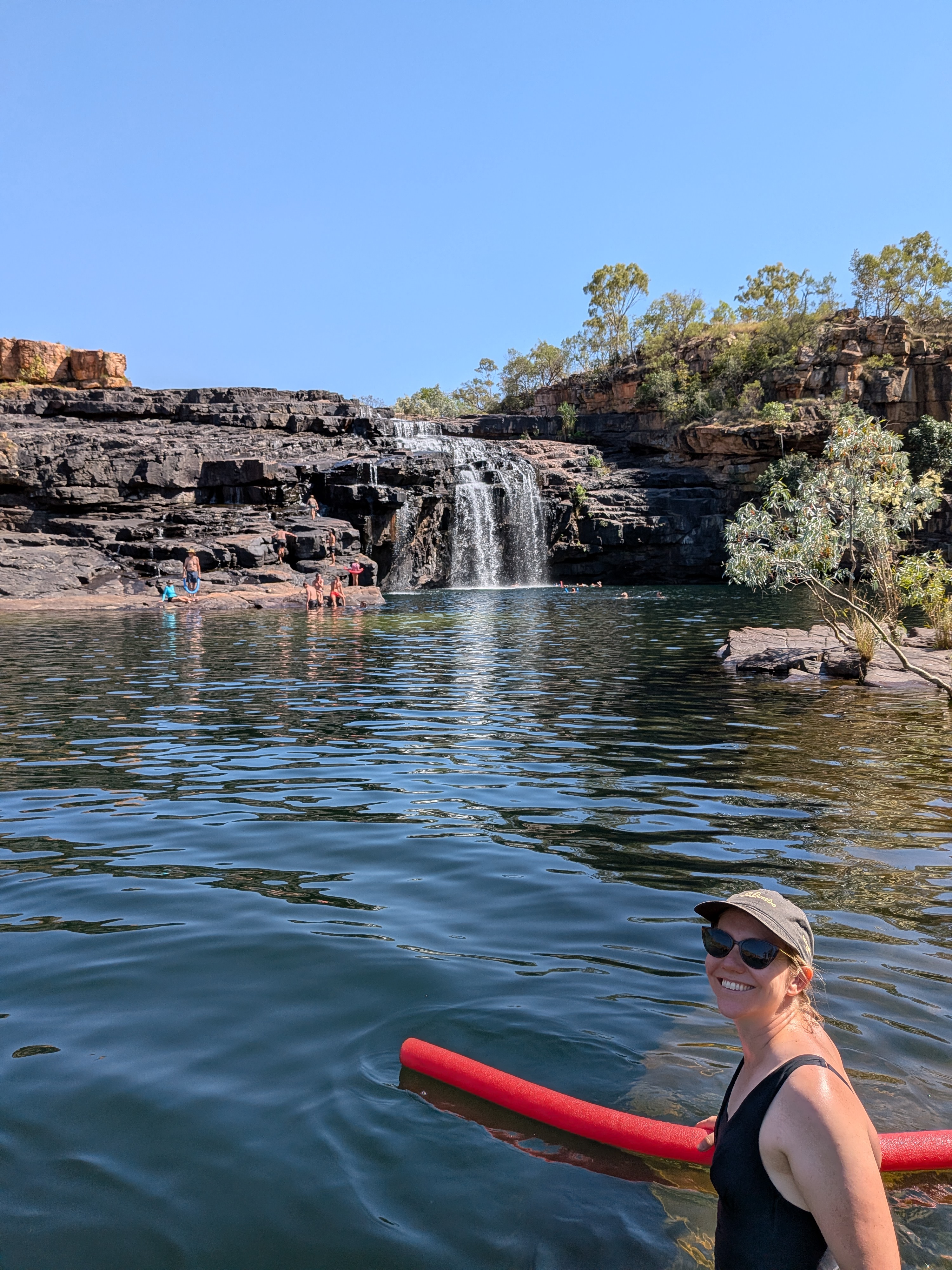 Erin in front of the falls, red noodle in hand