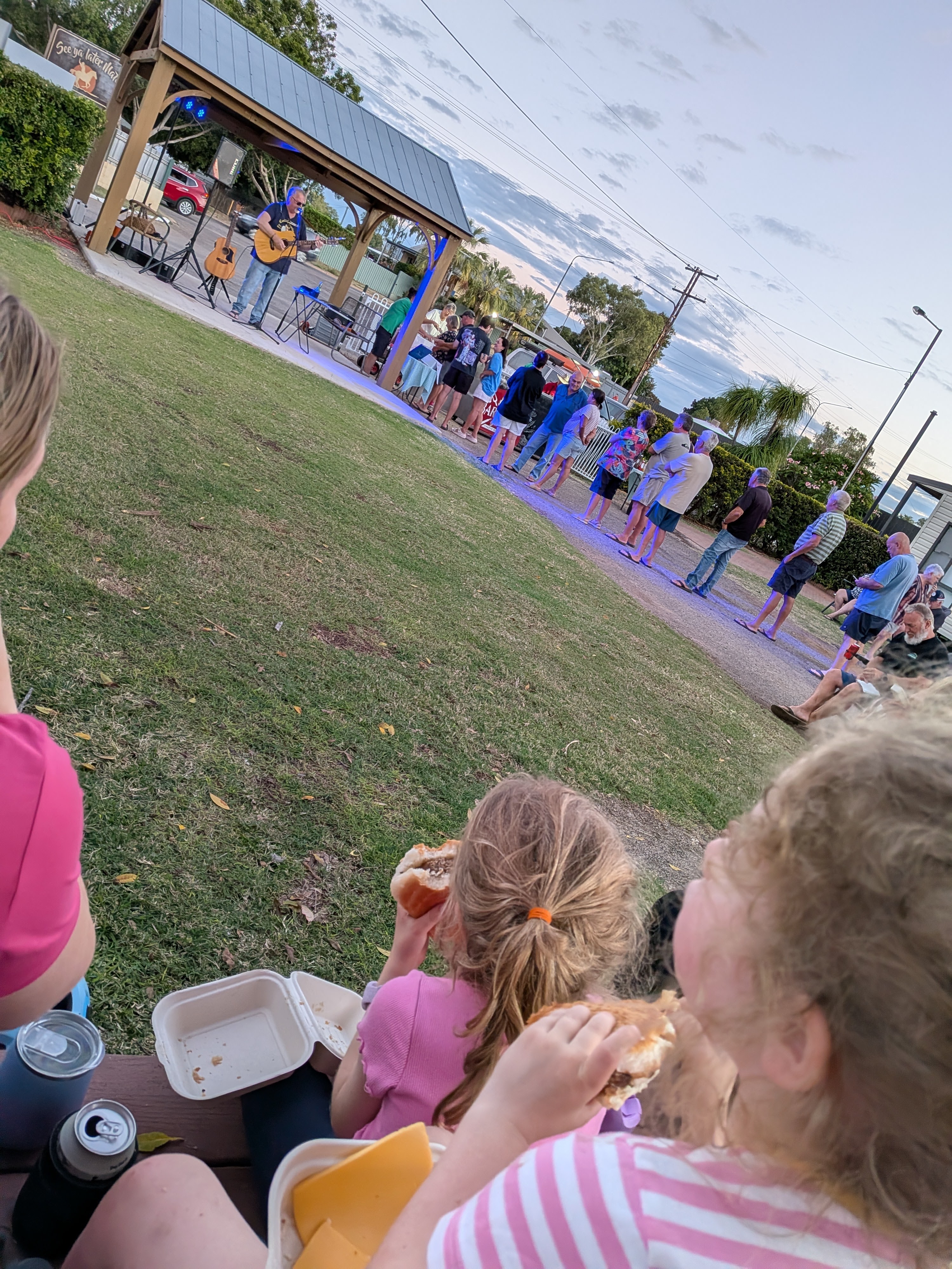 The girls eating burgers watching live music at the caravan park