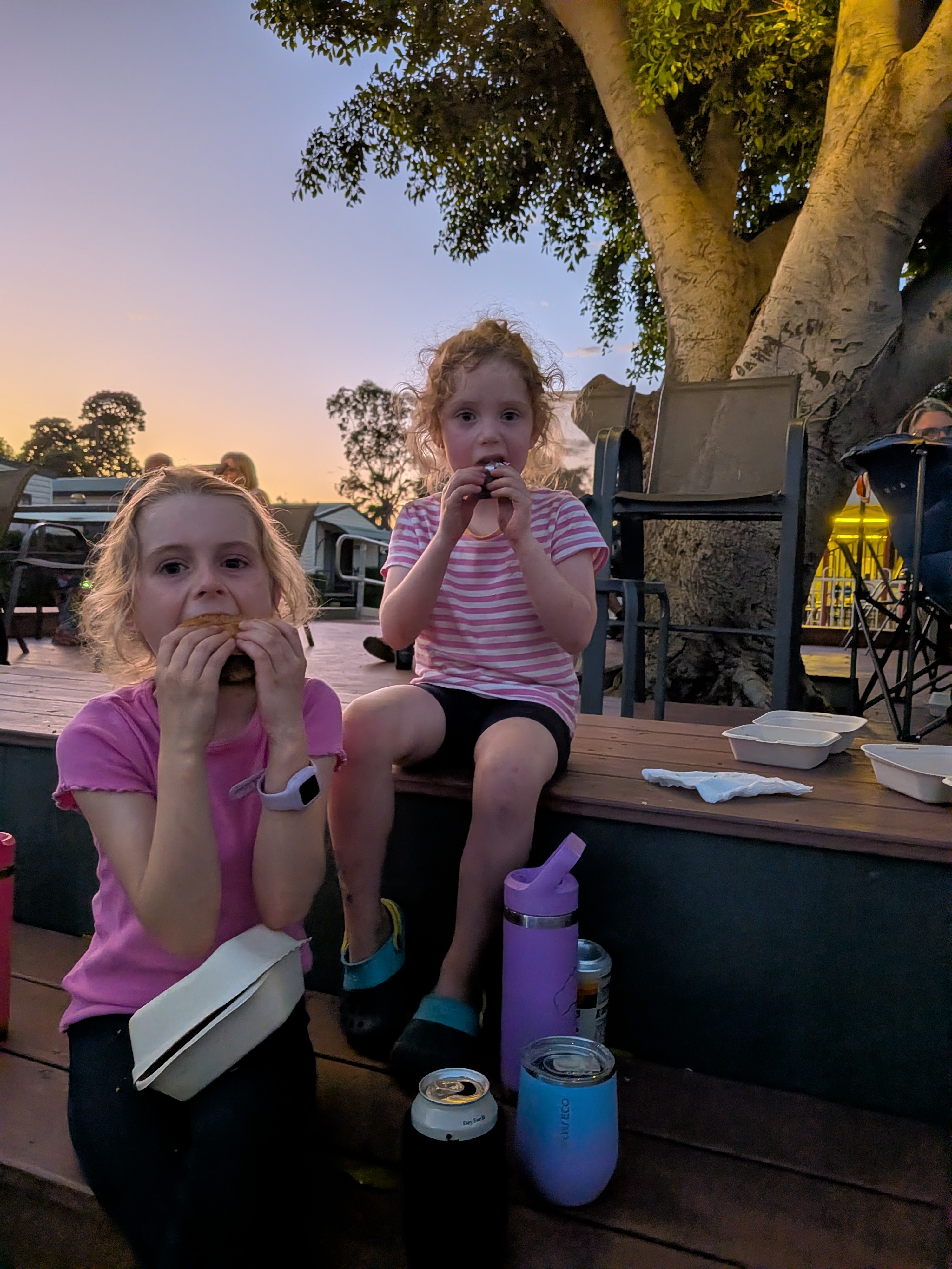 Hazel and Leah tucking into bloody big burgers at sunset