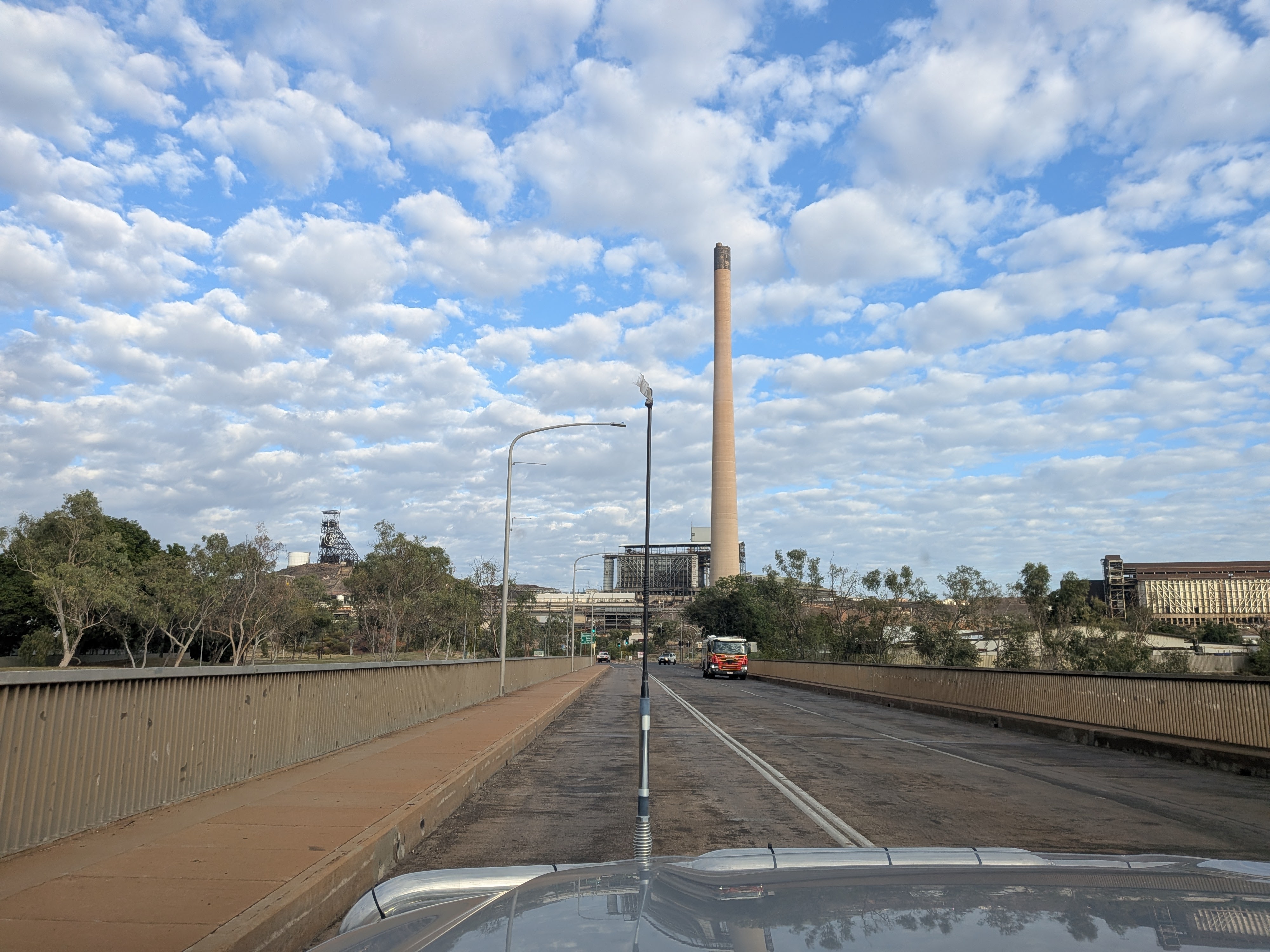 Driving through Mount Isa — mine stack and industrial skyline