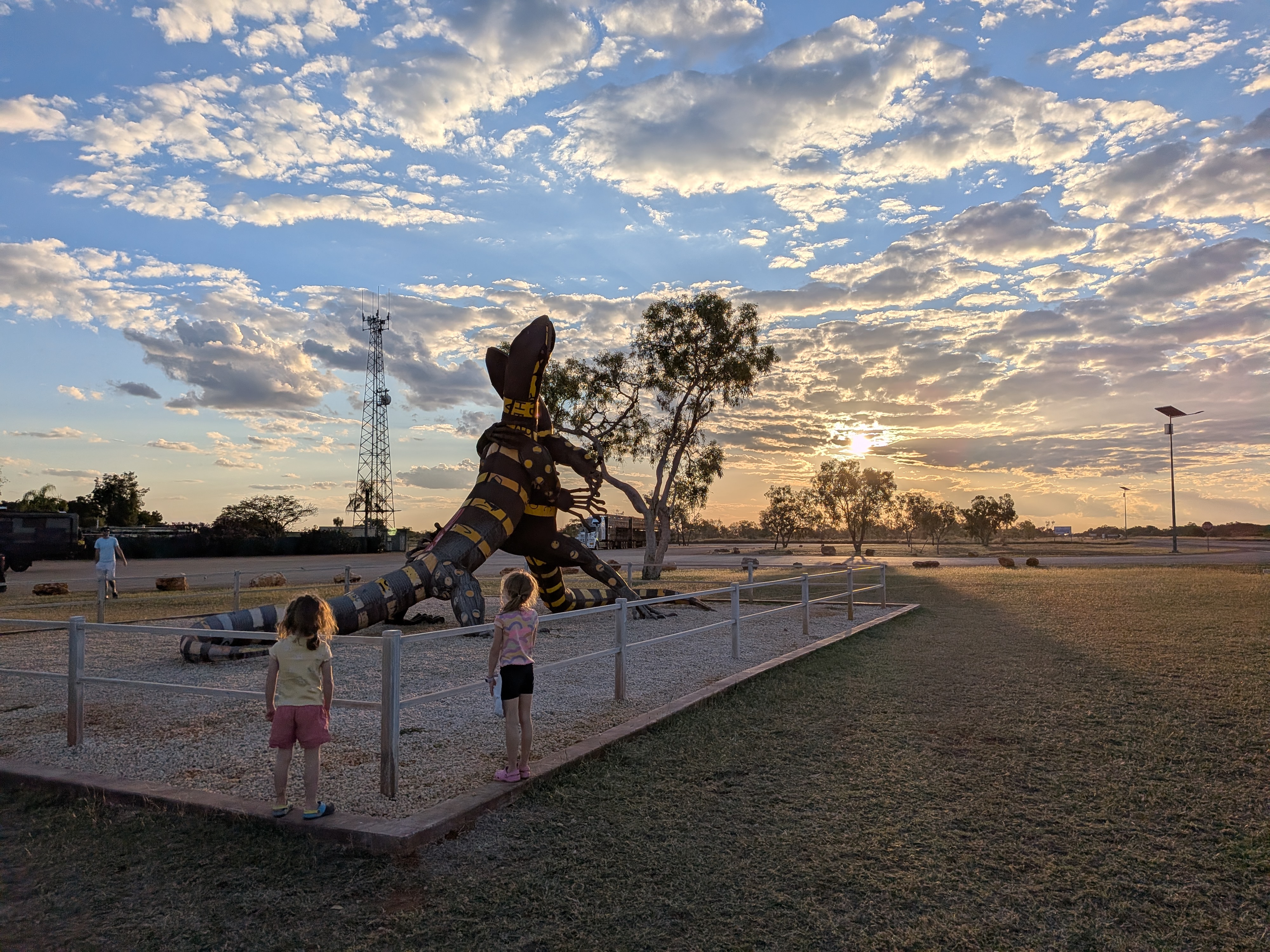 The girls looking at the giant goanna sculpture at sunset